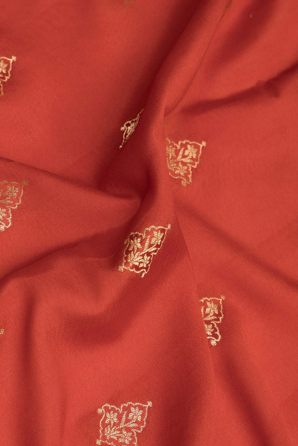 Close up of Pure Silk Rust Dual Tone Banarasi Georgette Saree with Zari Butta on the body and Zari Border.  displaying folds