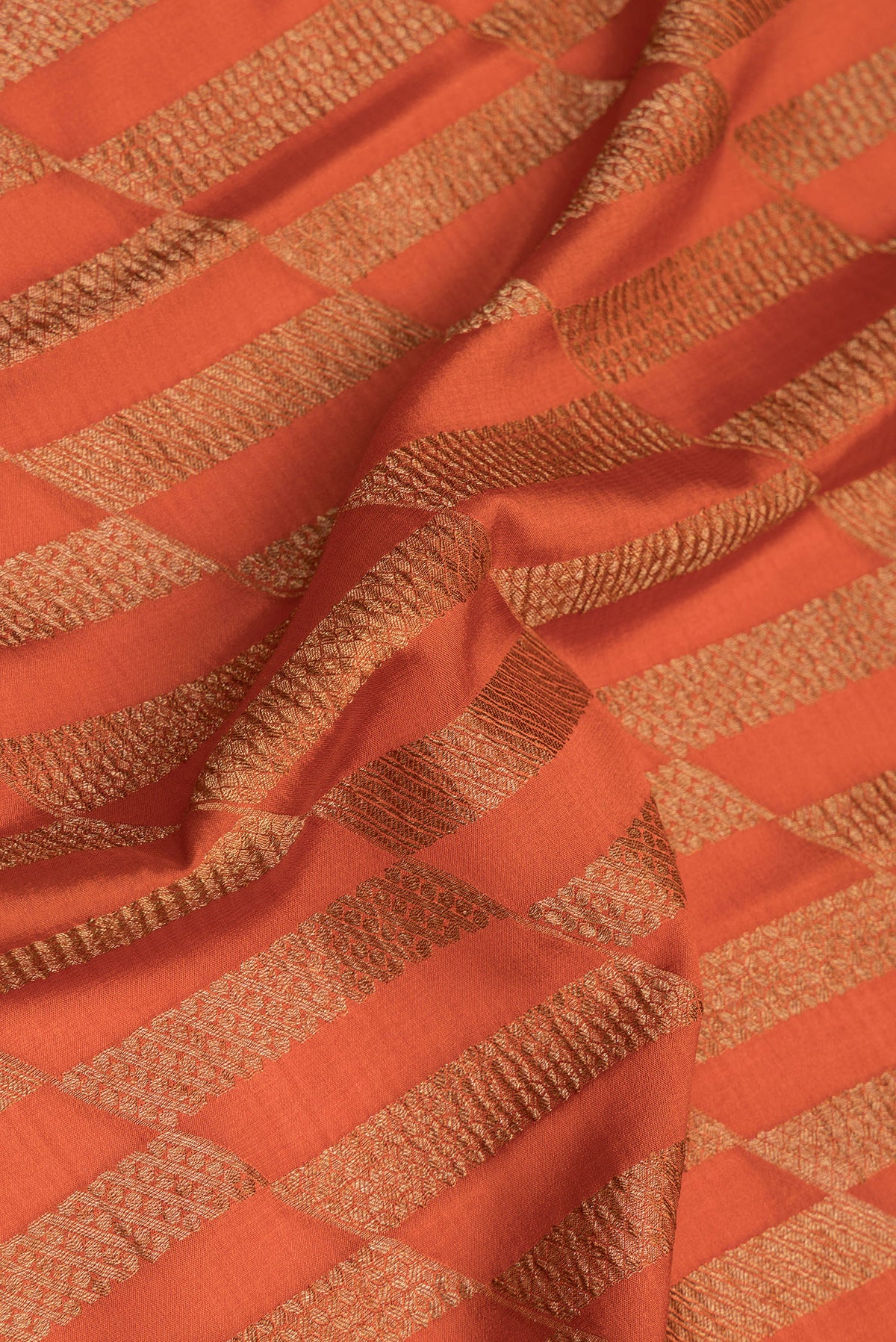 Close up of Pure Silk Rust Dual Tone Banarasi Georgette Saree with Zari Brocade on the body and Zari Border.  displaying folds