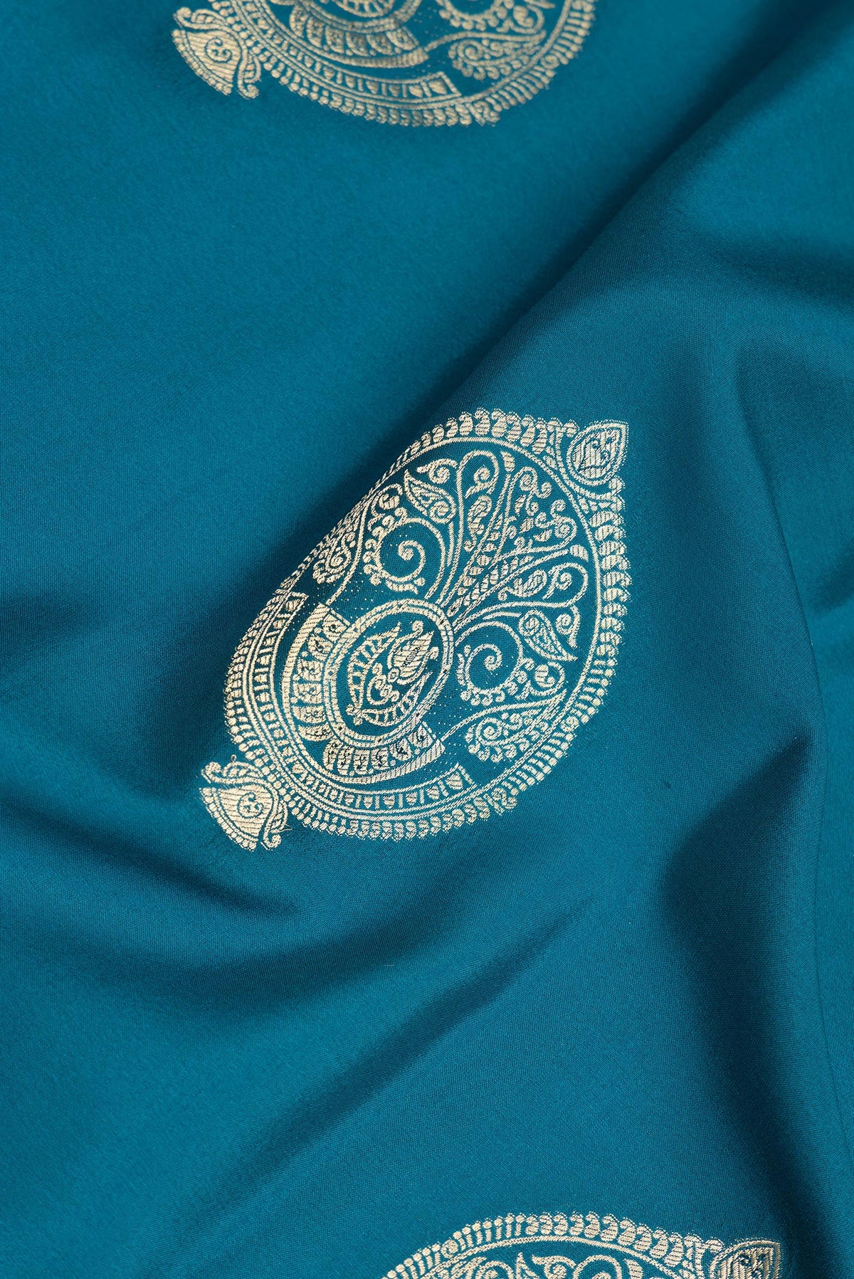 Close up of Pure Silk Peacock Blue Dual Tone Banarasi Georgette Saree with Zari Butta on the body and Zari Border.  displaying folds