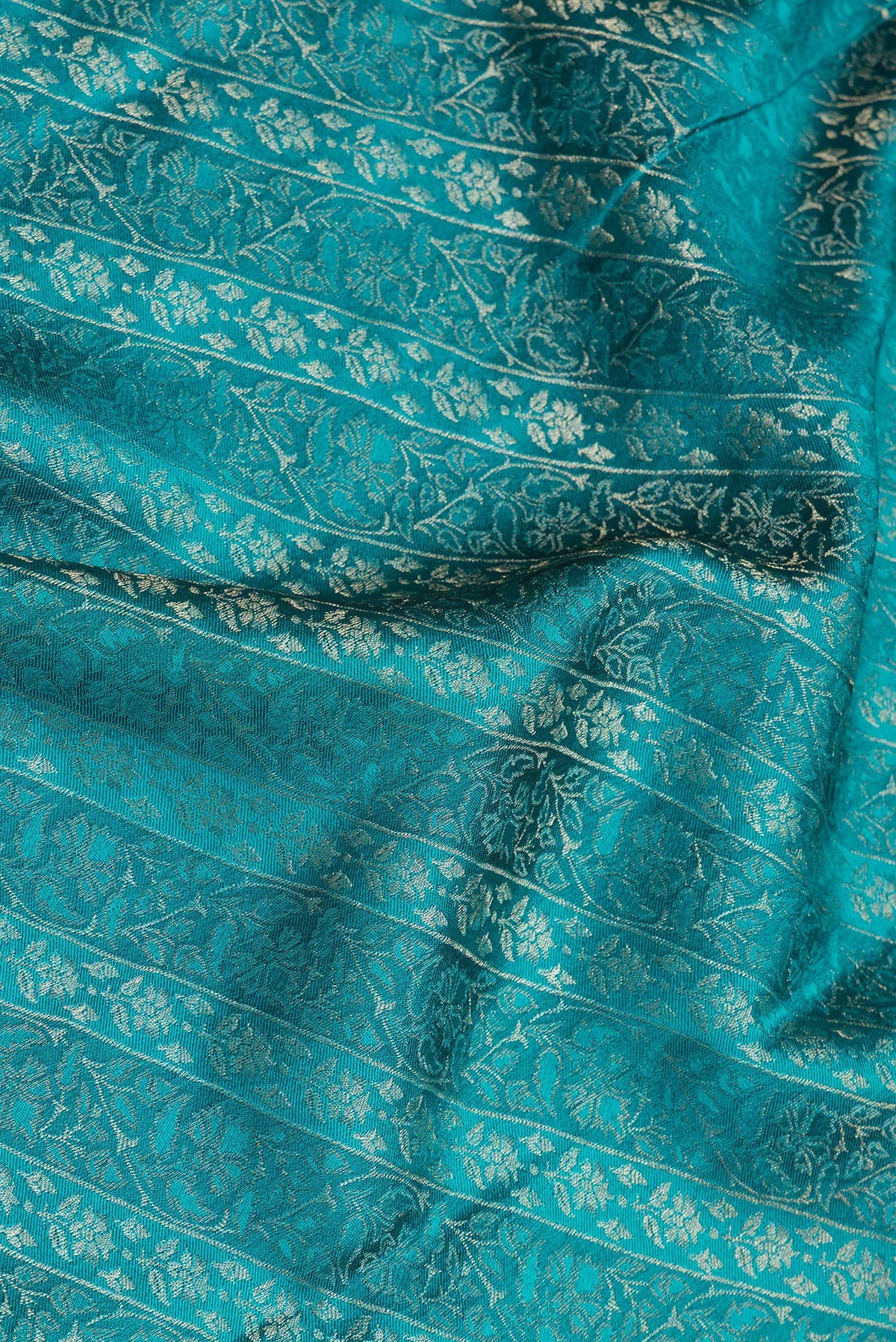 Close up of Pure Silk Peacock Blue Dual Tone Banarasi Georgette Saree with Zari Brocade on the body and Zari Border.  displaying folds