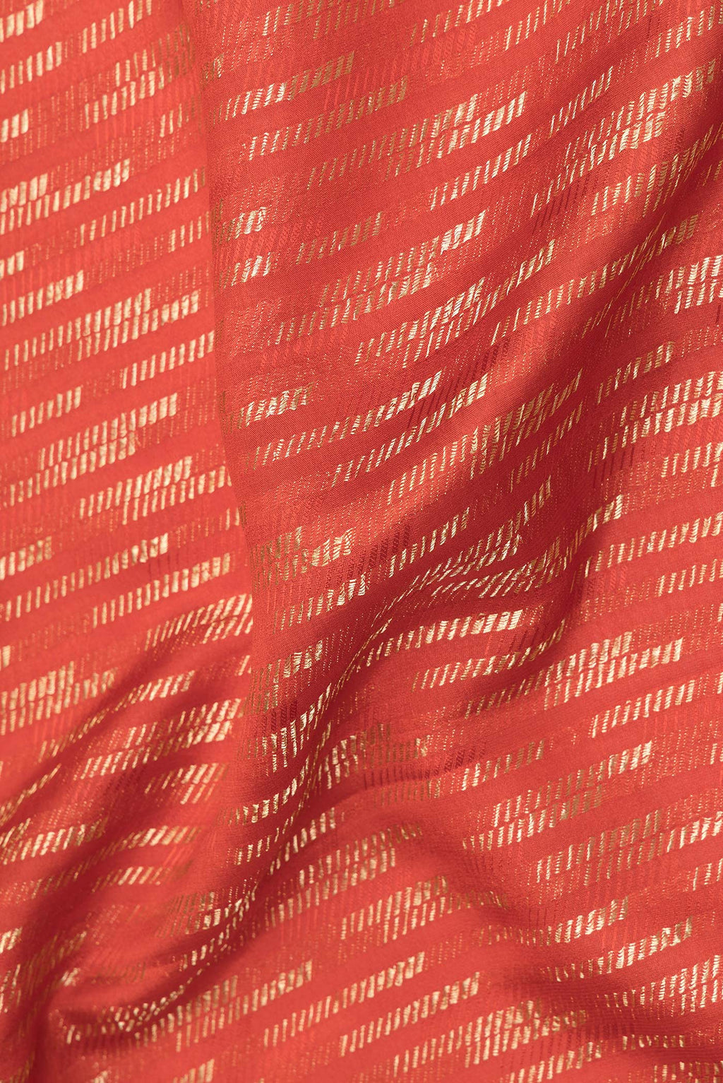 Close up of Rust Dual Tone Banarasi Georgette Saree with Zari Brocade on the body and Zari Border.  displaying folds
