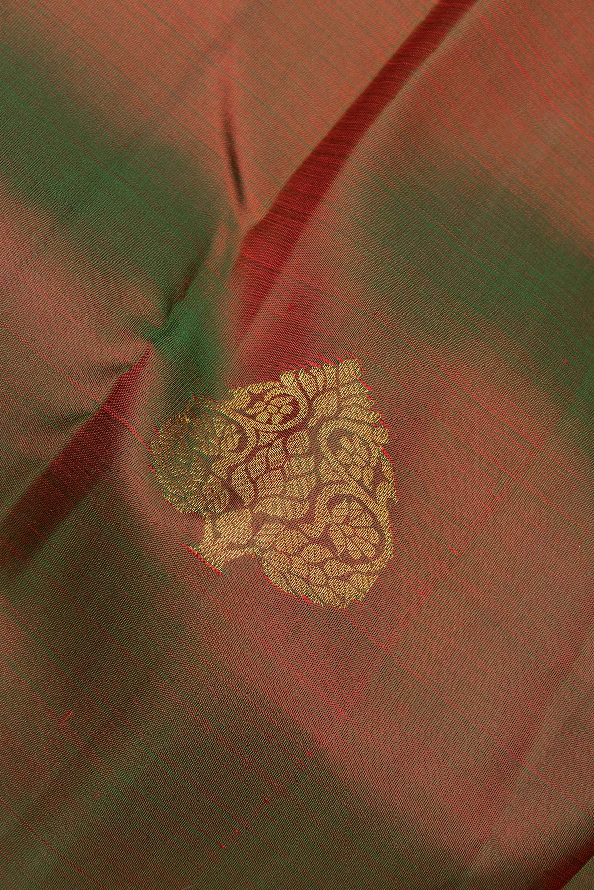 Close up of Pure Silk Mehandi Green Dual Tone Kanjivaram Saree with Zari Butta on the body and Zari Border.  displaying folds