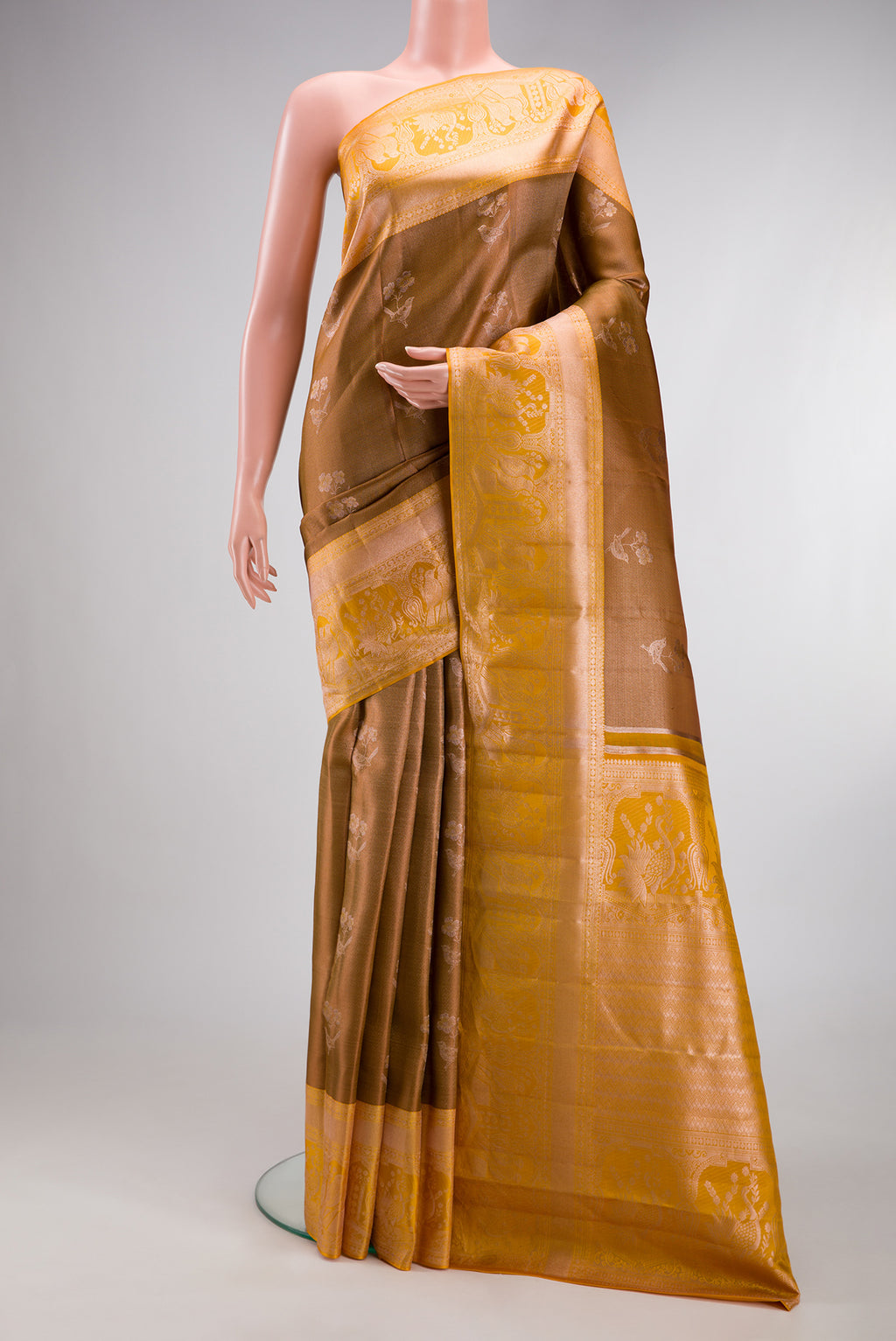 Brown Dual Tone Kanchipuram Tissue Silk Saree with Zari Butta on the body and Fancy Border.  displayed on a mannequin