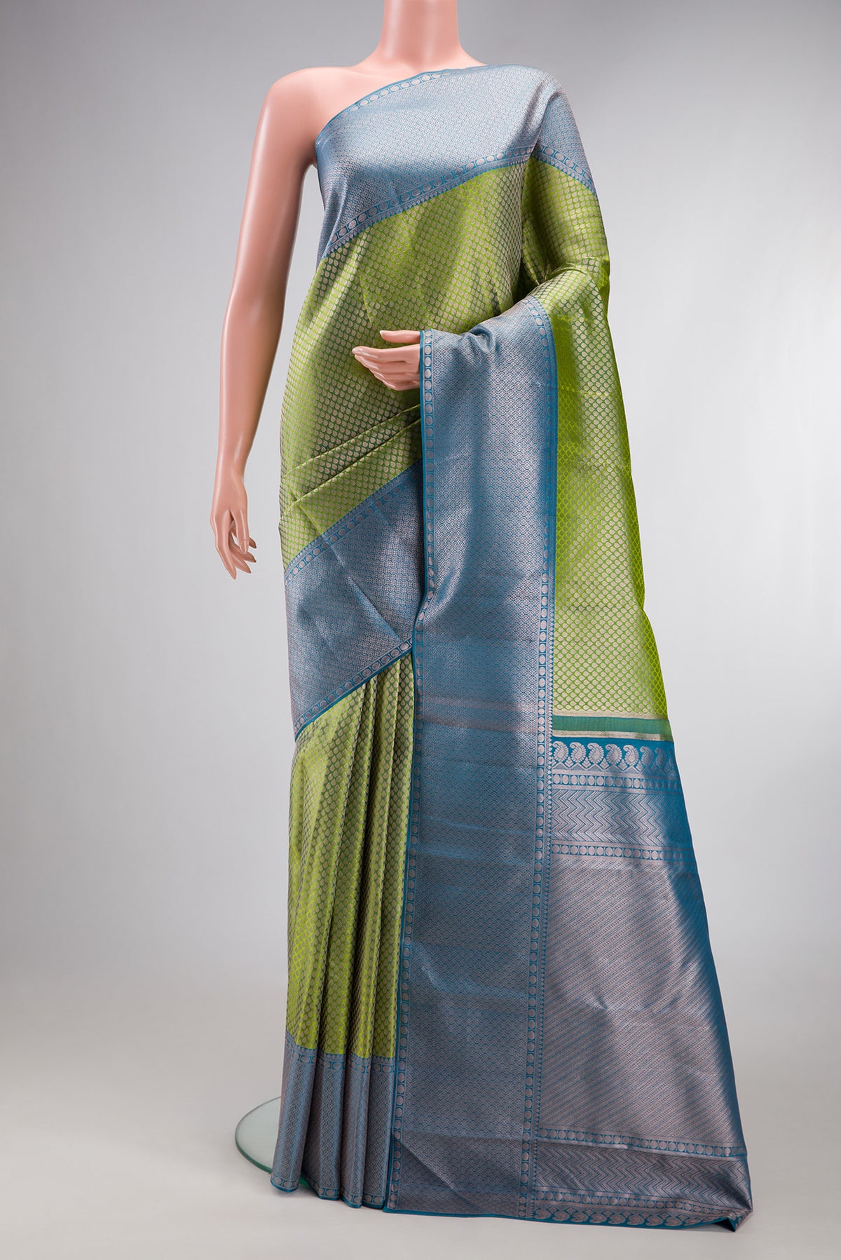 Green Kanchipuram Tissue Silk Saree with Zari Brocade on the body and Zari Border.  displayed on a mannequin