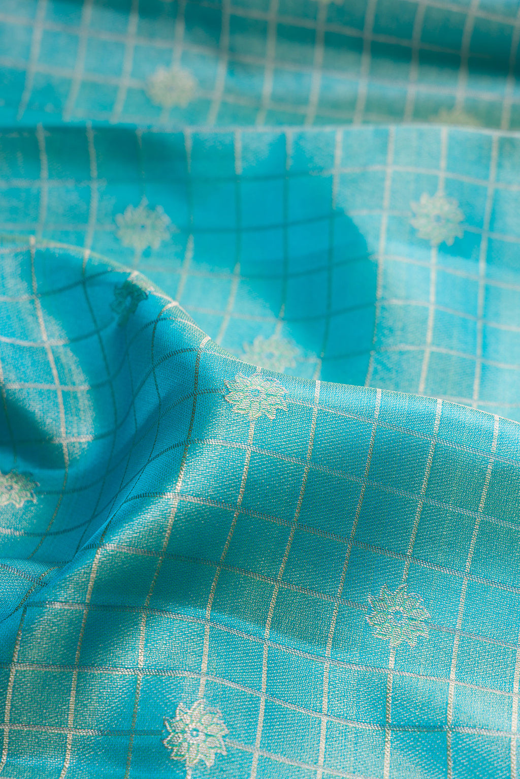 Close up of Sky Blue Dual Tone Kanchipuram Tissue Silk Saree with Checked design on the body and Fancy Border.  displaying folds