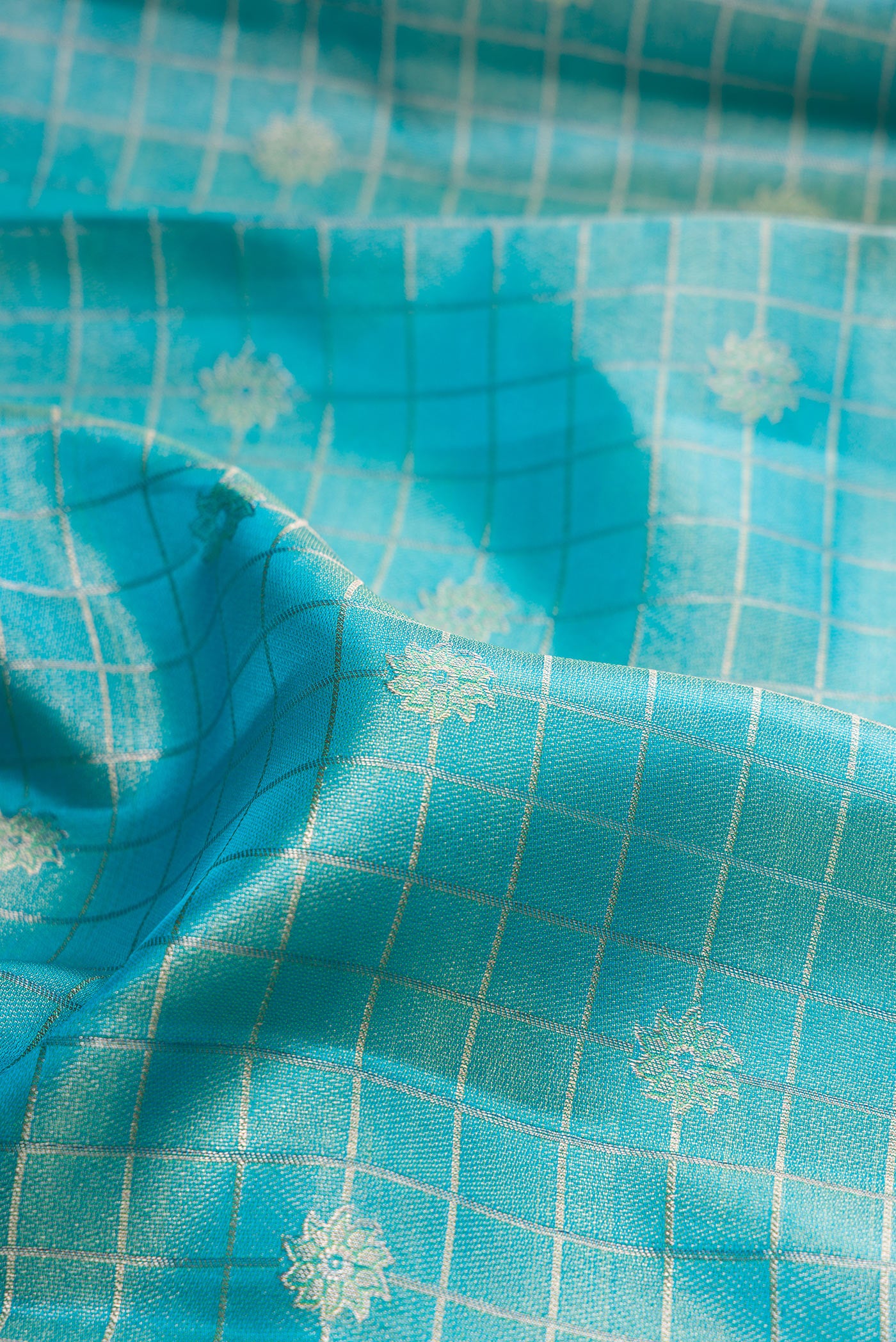 Close up of Sky Blue Dual Tone Kanchipuram Tissue Silk Saree with Checked design on the body and Fancy Border.  displaying folds