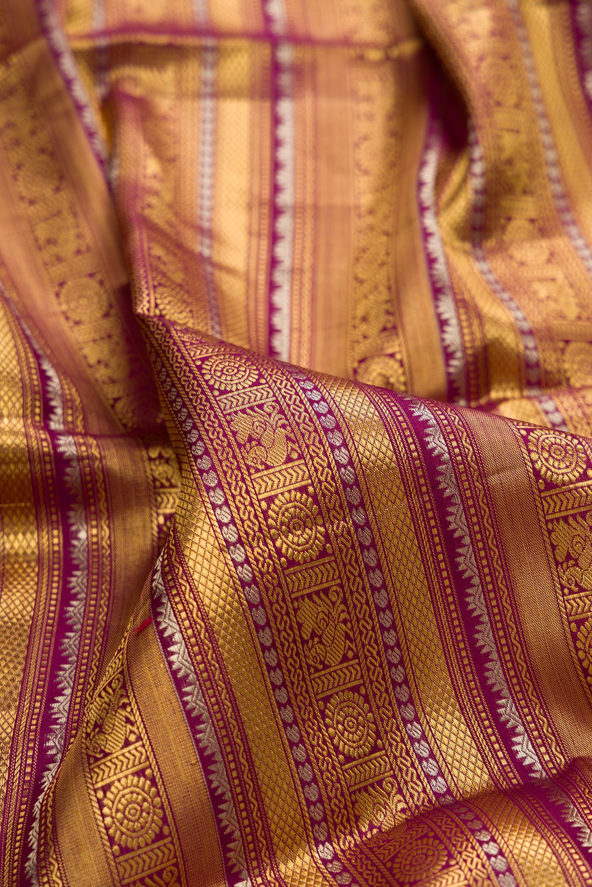 Close up of Pure Silk Purple Kanchipuram Saree with Zari Brocade on the body and Fancy Border.  displaying folds