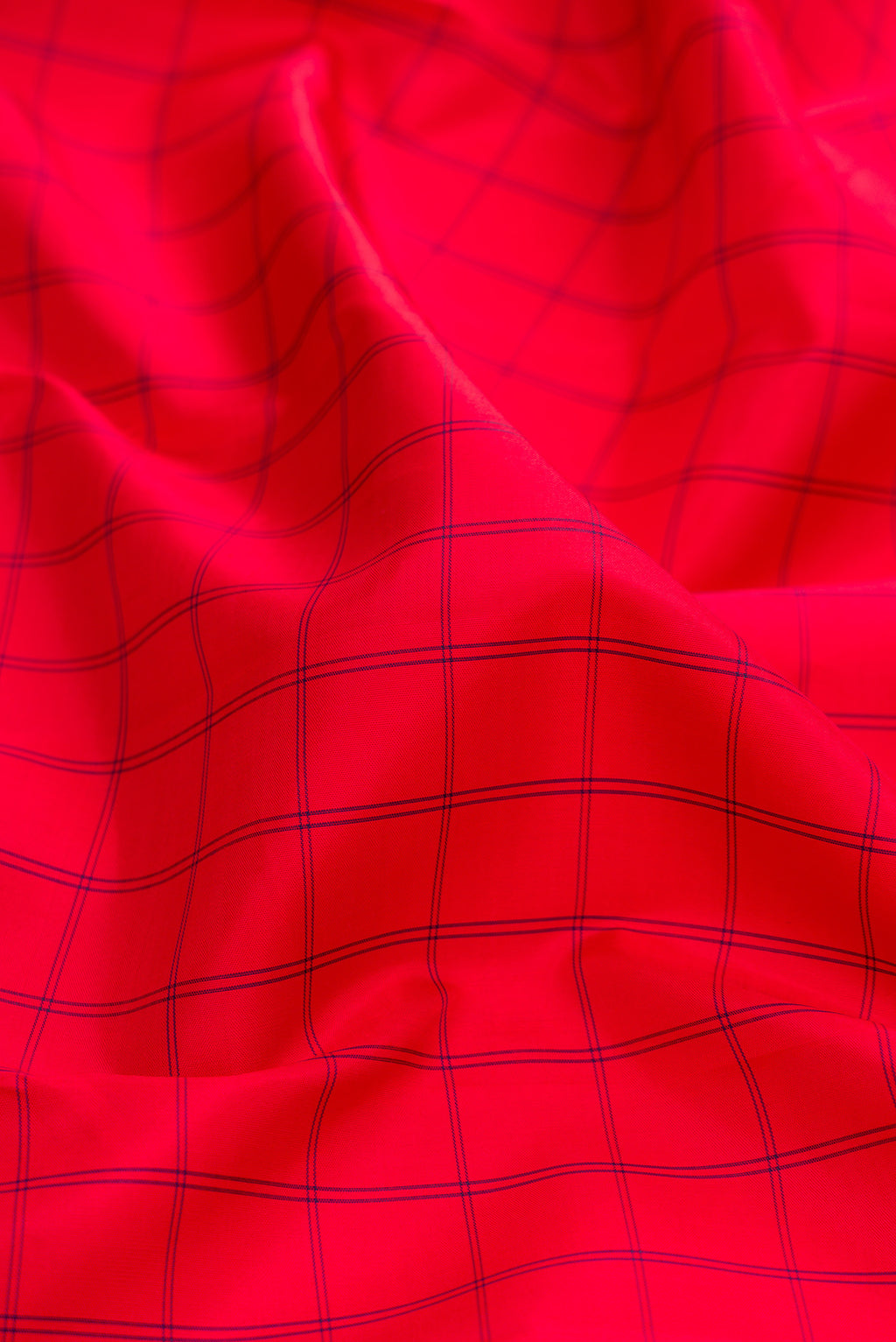 Close up of Pure Silk Red Kanjivaram Saree with Checked design on the body and Zari Border.  displaying folds