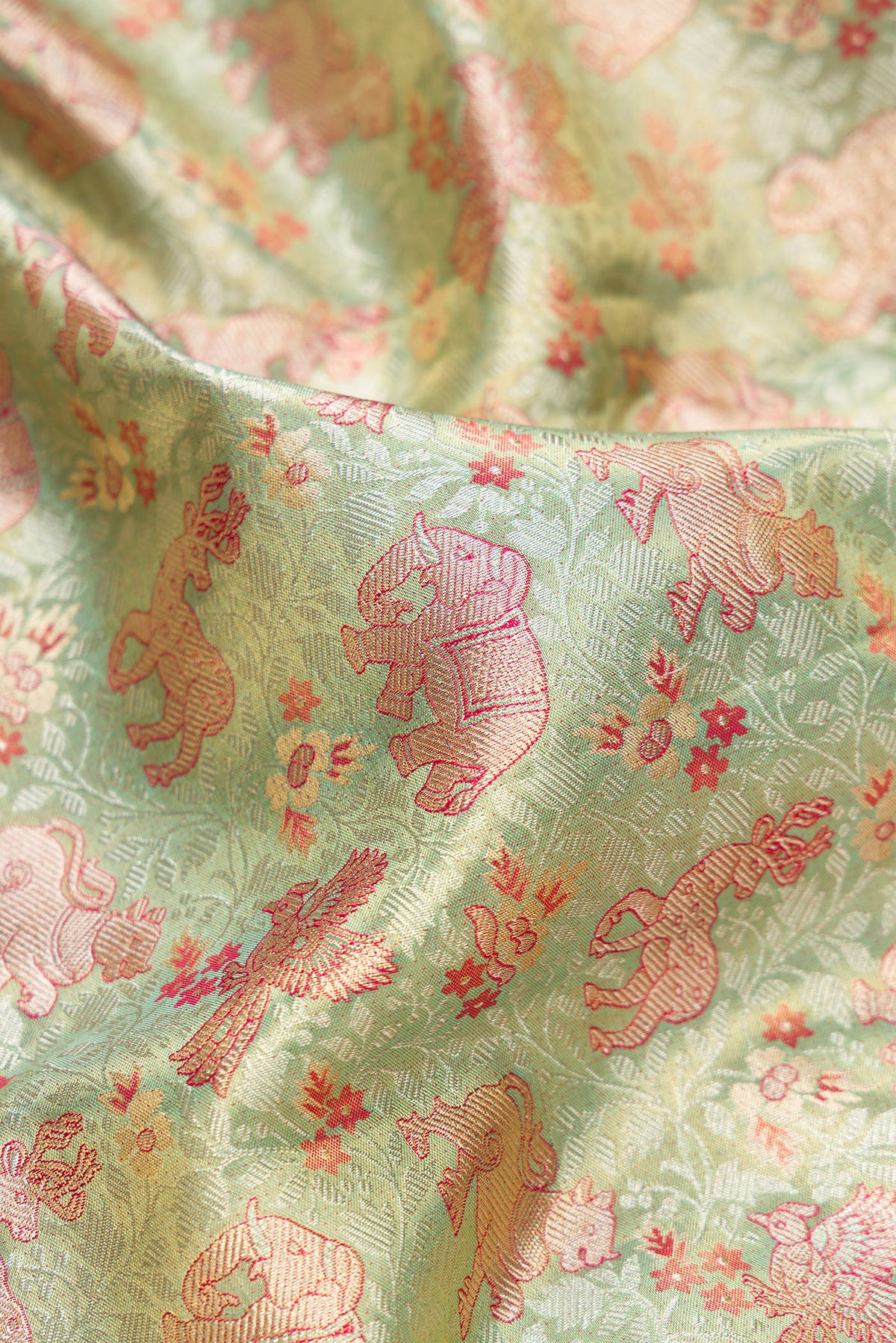 Close up of Pista Green Dual Tone Kanjivaram Tissue Saree with Zari Brocade on the body and Zari Border.  displaying folds
