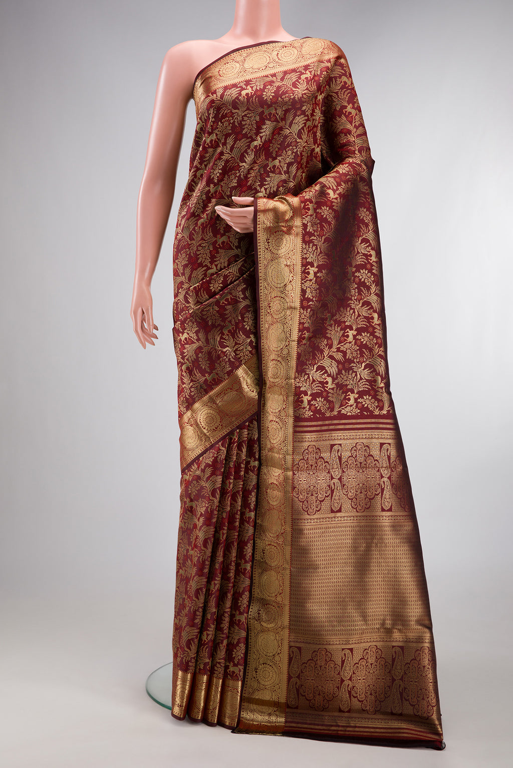 Maroon Kanjivaram Silk Saree with Zari Brocade on the body and Zari Border.  displayed on a mannequin