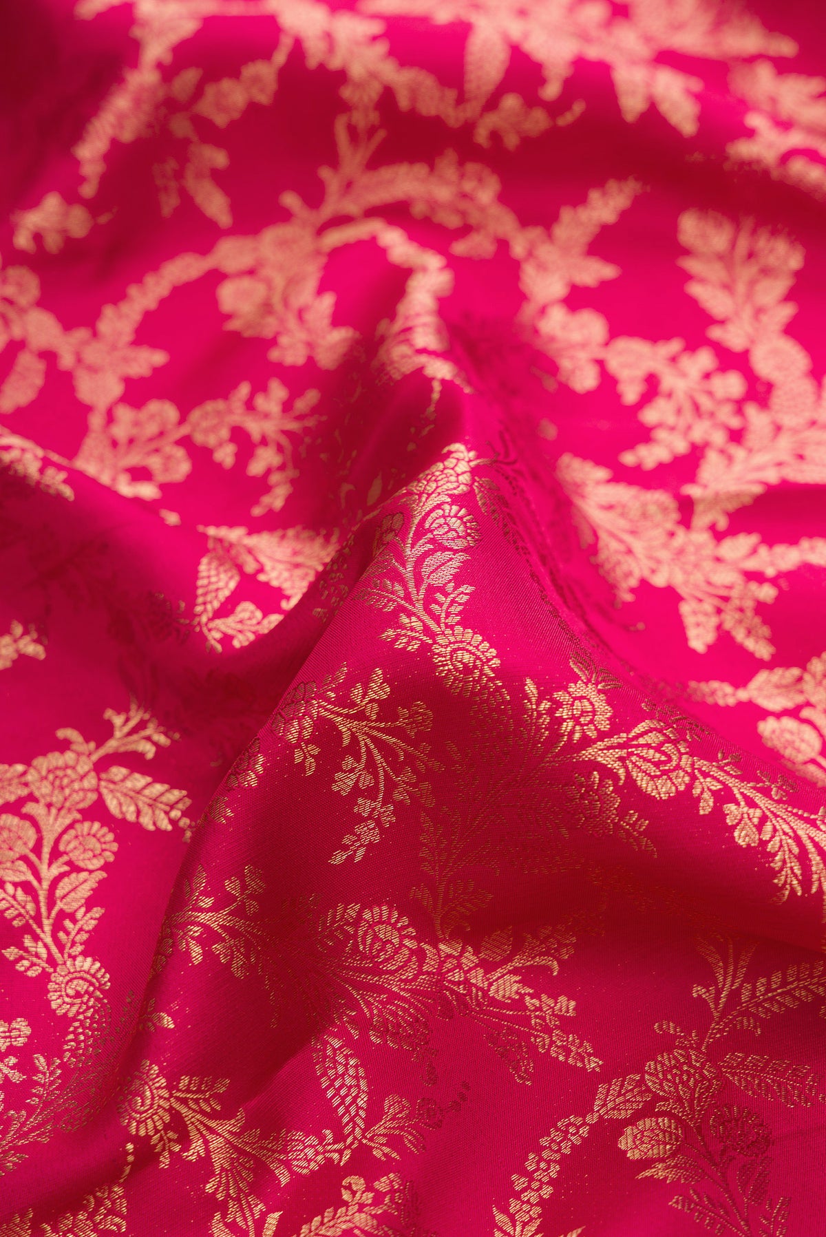 Close up of Pure Silk Dark Pink Dual Tone Kanjivaram Saree with Zari Brocade on the body and Zari Border.  displaying folds