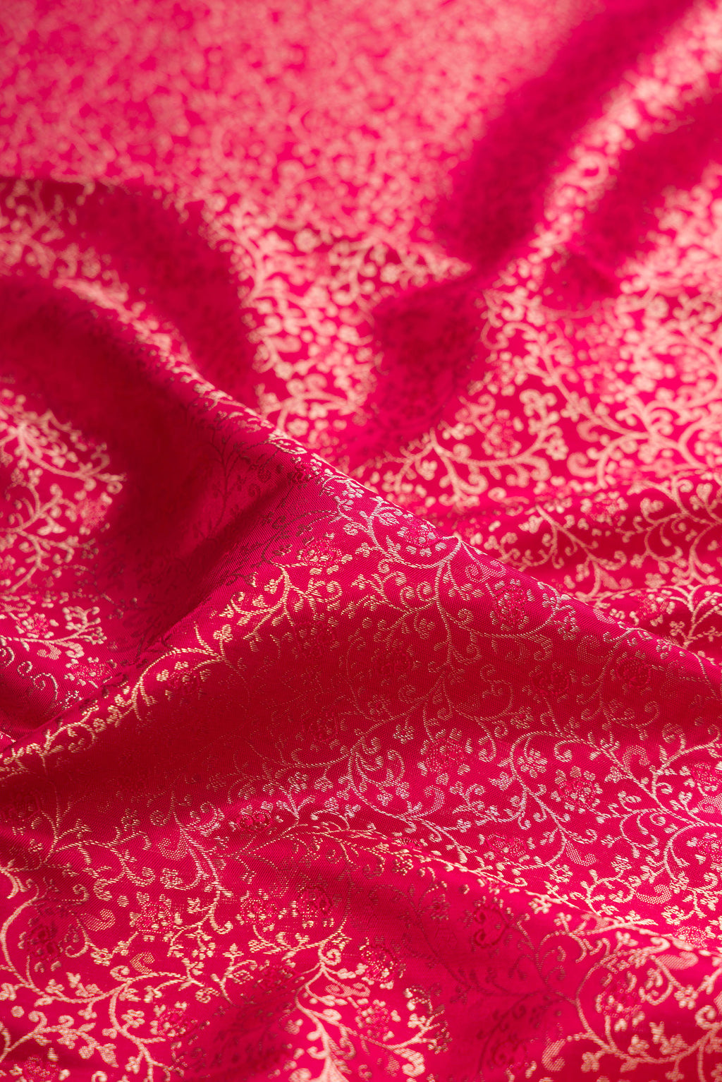 Close up of Dark Pink Kanjivaram Silk Saree with Zari Brocade on the body and Paithani Border.  displaying folds