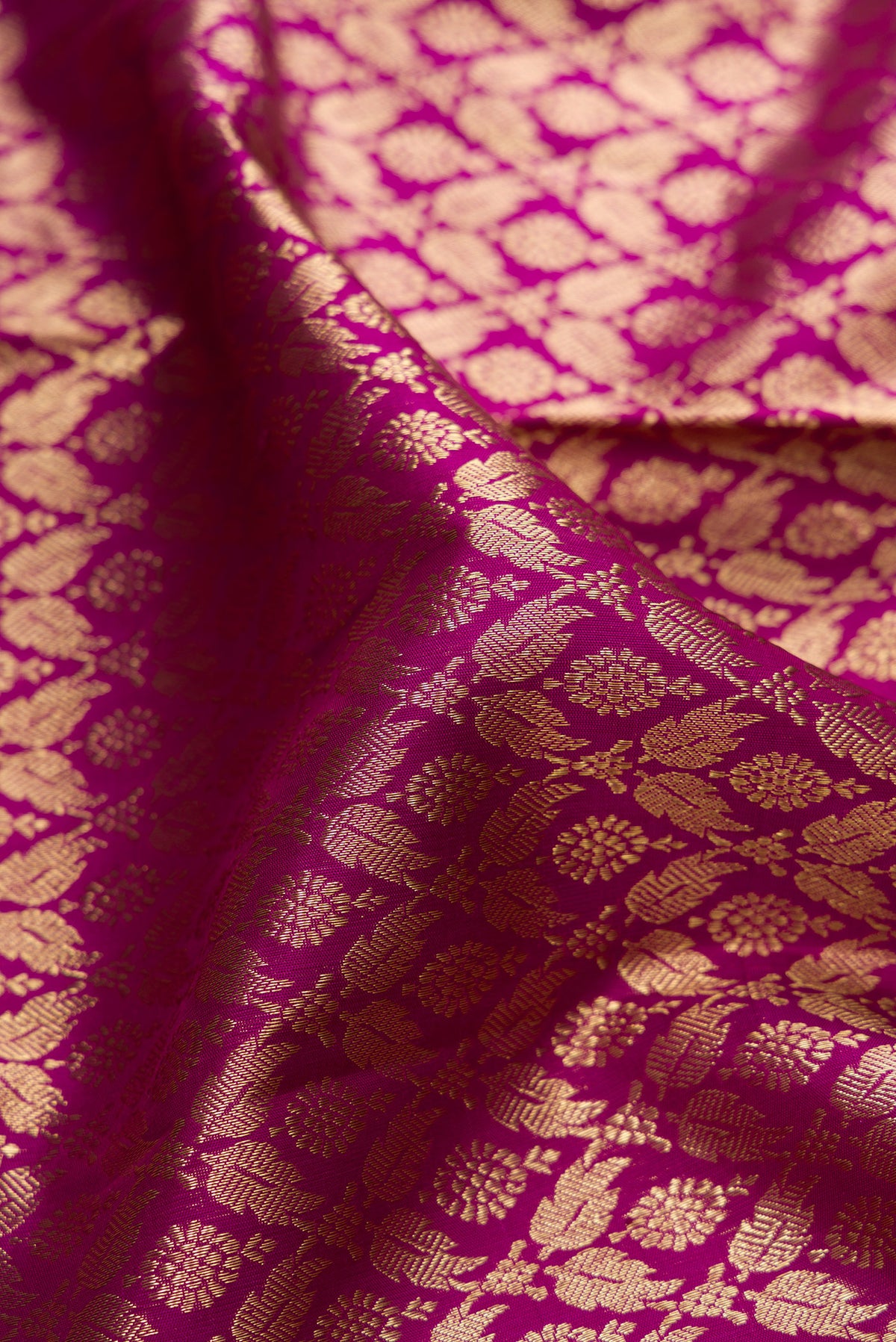 Close up of Pure Silk Magenta Dual Tone Kanjivaram Saree with Zari Brocade on the body and Zari Border.  displaying folds