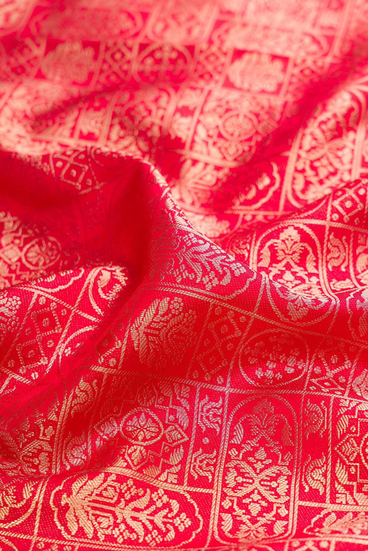 Close up of Red Kanjivaram Silk Saree with Zari Brocade on the body and Fancy Border.  displaying folds