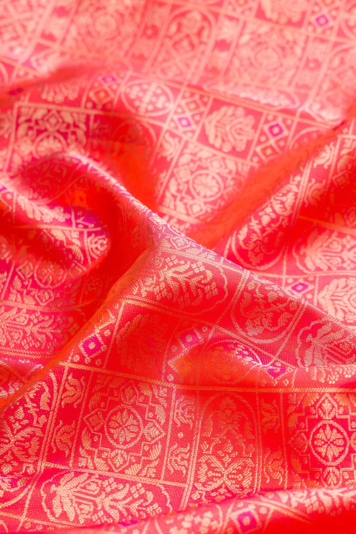 Close up of Orange Dual Tone Kanjivaram Silk Saree with Zari Brocade on the body and Fancy Border.  displaying folds