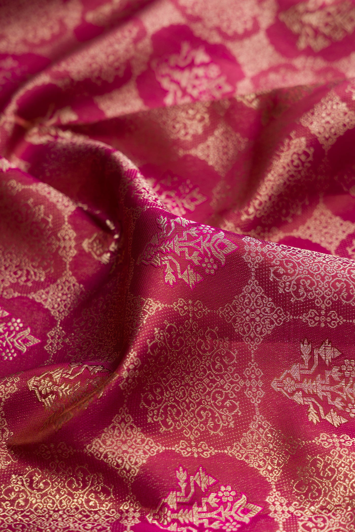 Close up of Magenta Dual Tone Kanjivaram Silk Saree with Zari Brocade on the body and Fancy Border.  displaying folds