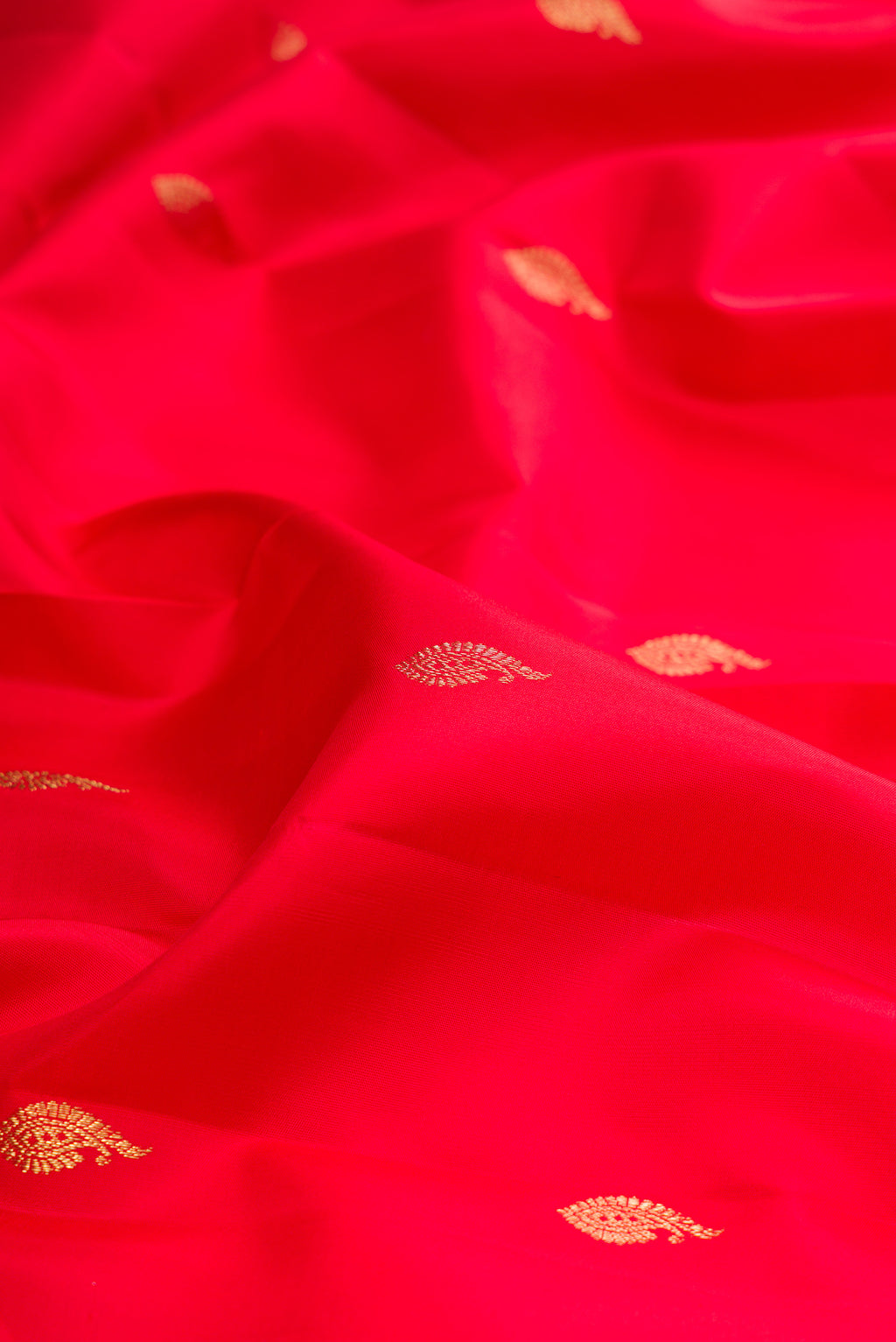 Close up of Pure Silk Red Kanjivaram Saree with Zari Butta on the body and Zari Border.  displaying folds
