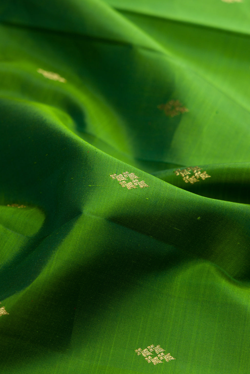 Close up of Pure Silk Green Kanjivaram Saree with Zari Butta on the body and Zari Border.  displaying folds