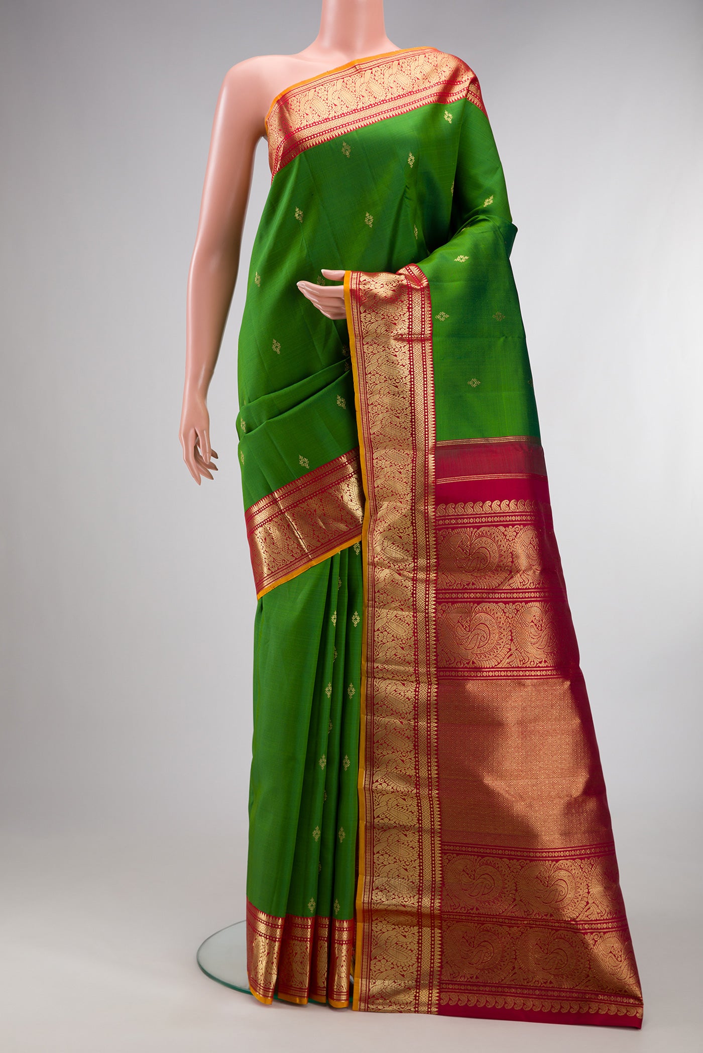 Pure Silk Green Kanjivaram Saree with Zari Butta on the body and Zari Border.  displayed on a mannequin