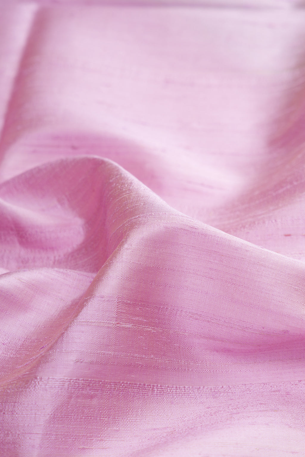 Close up of Pure Silk Lavender Raw Saree with Plain Body and Zari Border.  displaying folds