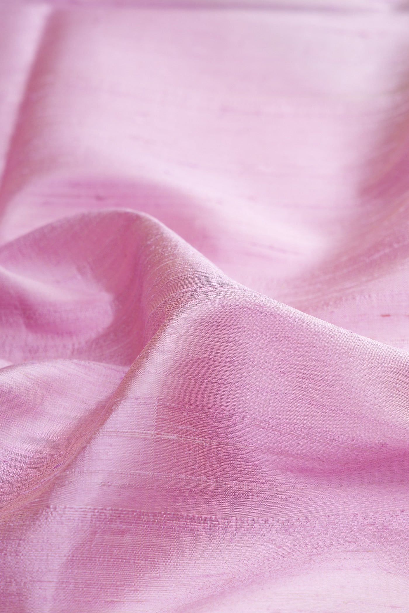 Close up of Pure Silk Lavender Raw Saree with Plain Body and Zari Border.  displaying folds