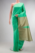 Pure Silk Sea Green Raw Saree with Plain Body and Fancy Border.  displayed on a mannequin