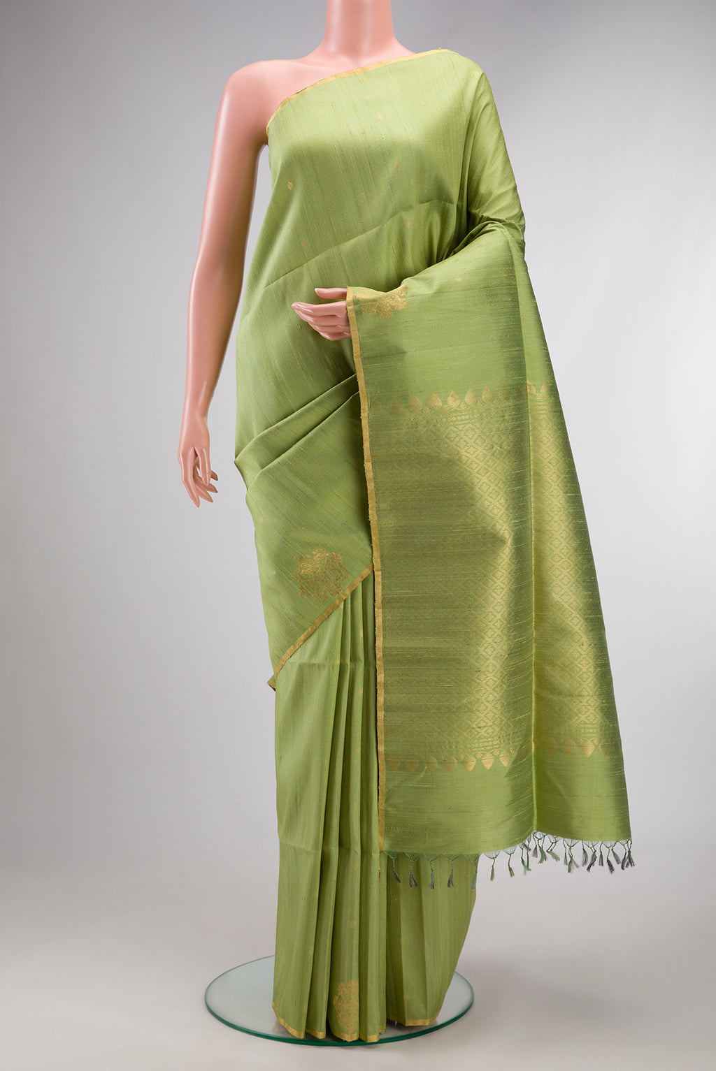 Pure Silk Pista Green Raw Saree with Zari Butta on the body and Zari Border.  displayed on a mannequin