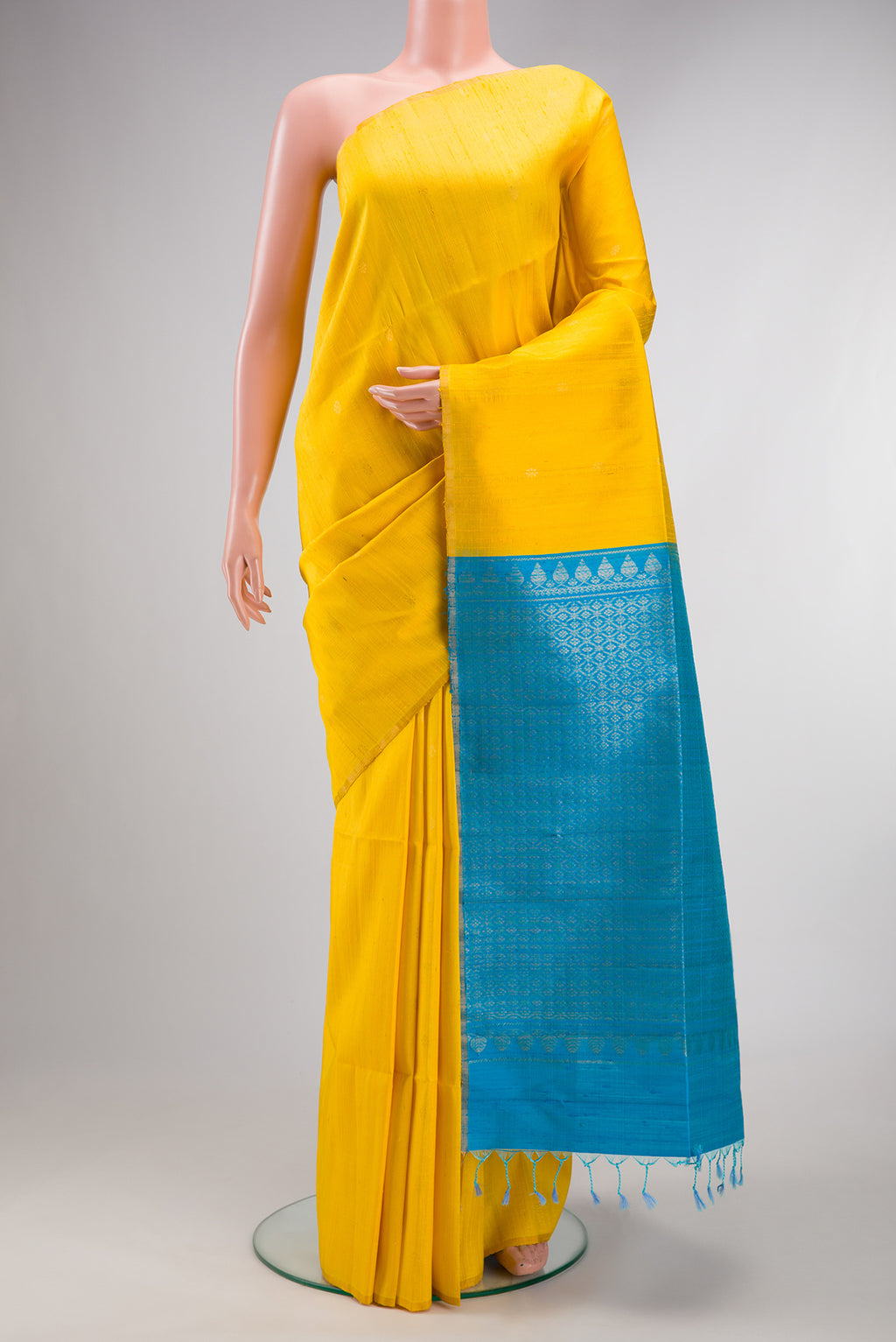 Pure Silk Yellow Raw Saree with Zari Butta on the body and Zari Border.  displayed on a mannequin
