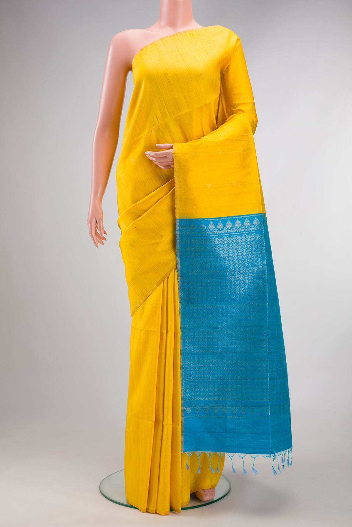 Pure Silk Yellow Raw Saree with Zari Butta on the body and Zari Border.  displayed on a mannequin