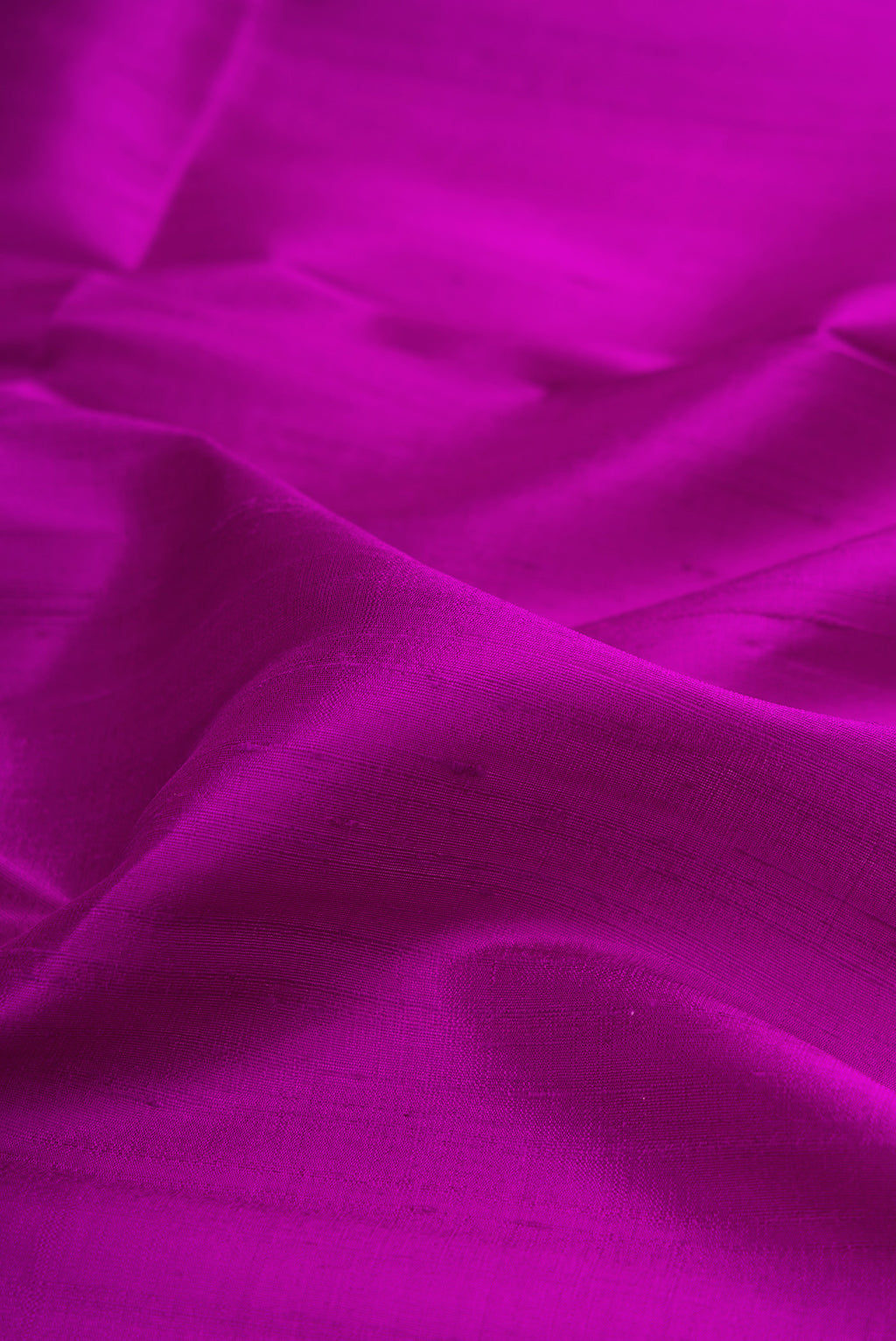 Close up of Pure Silk Purple Raw Saree with Plain Body and Zari Border.  displaying folds