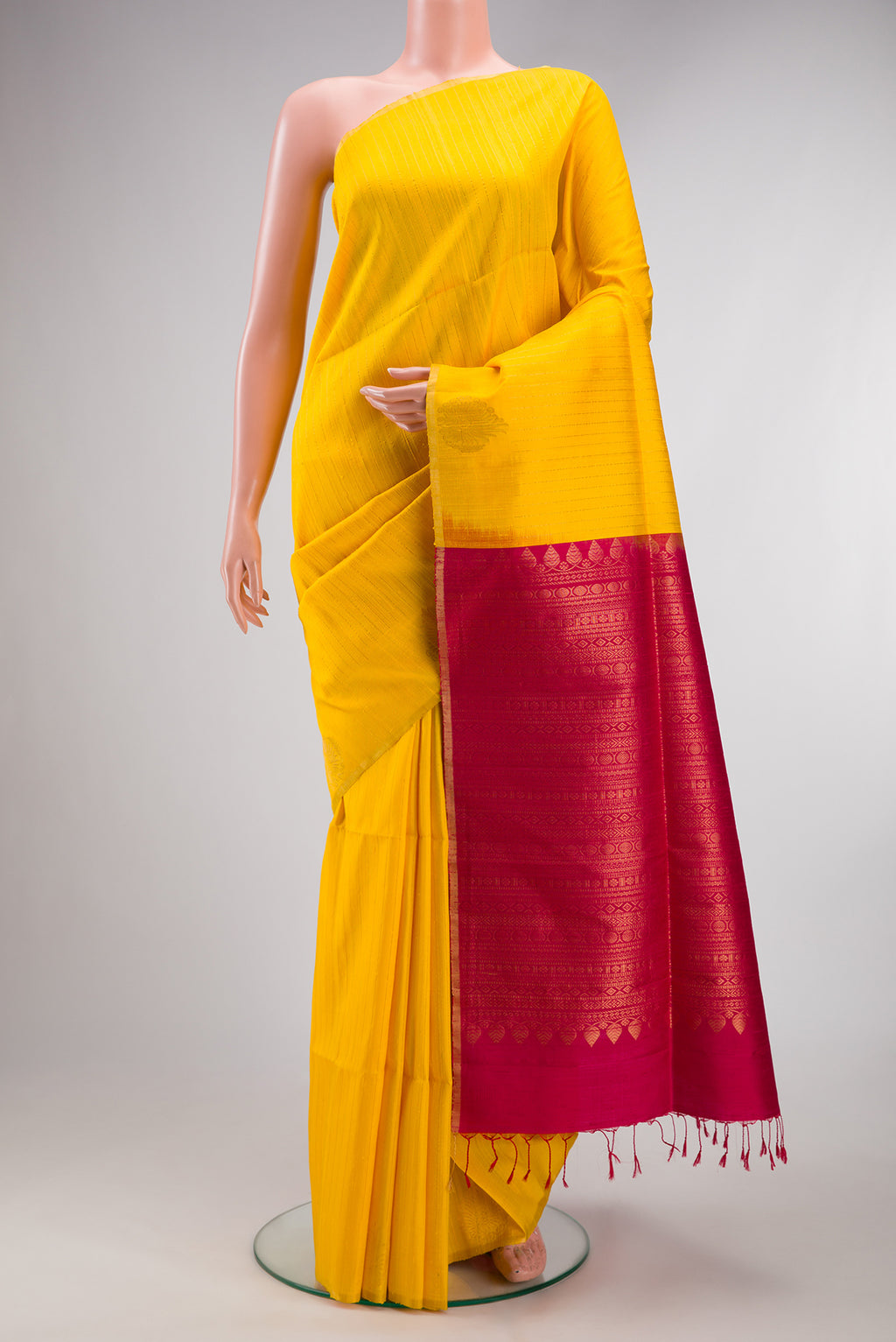 Pure Silk Yellow Raw Saree with Stripes on the body and Zari Border.  displayed on a mannequin