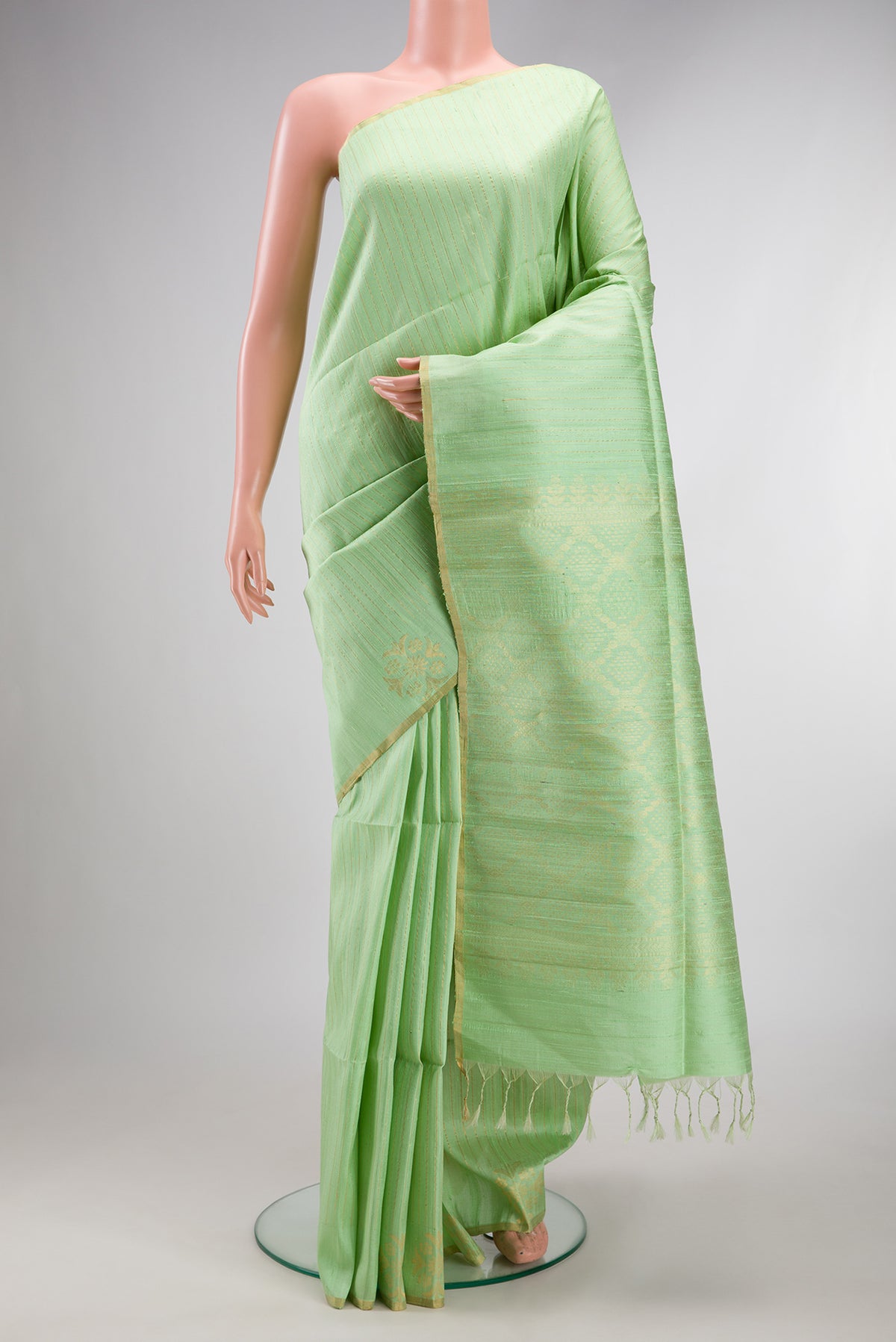 Pure Silk Pista Green Raw Saree with Stripes on the body and Zari Border.  displayed on a mannequin