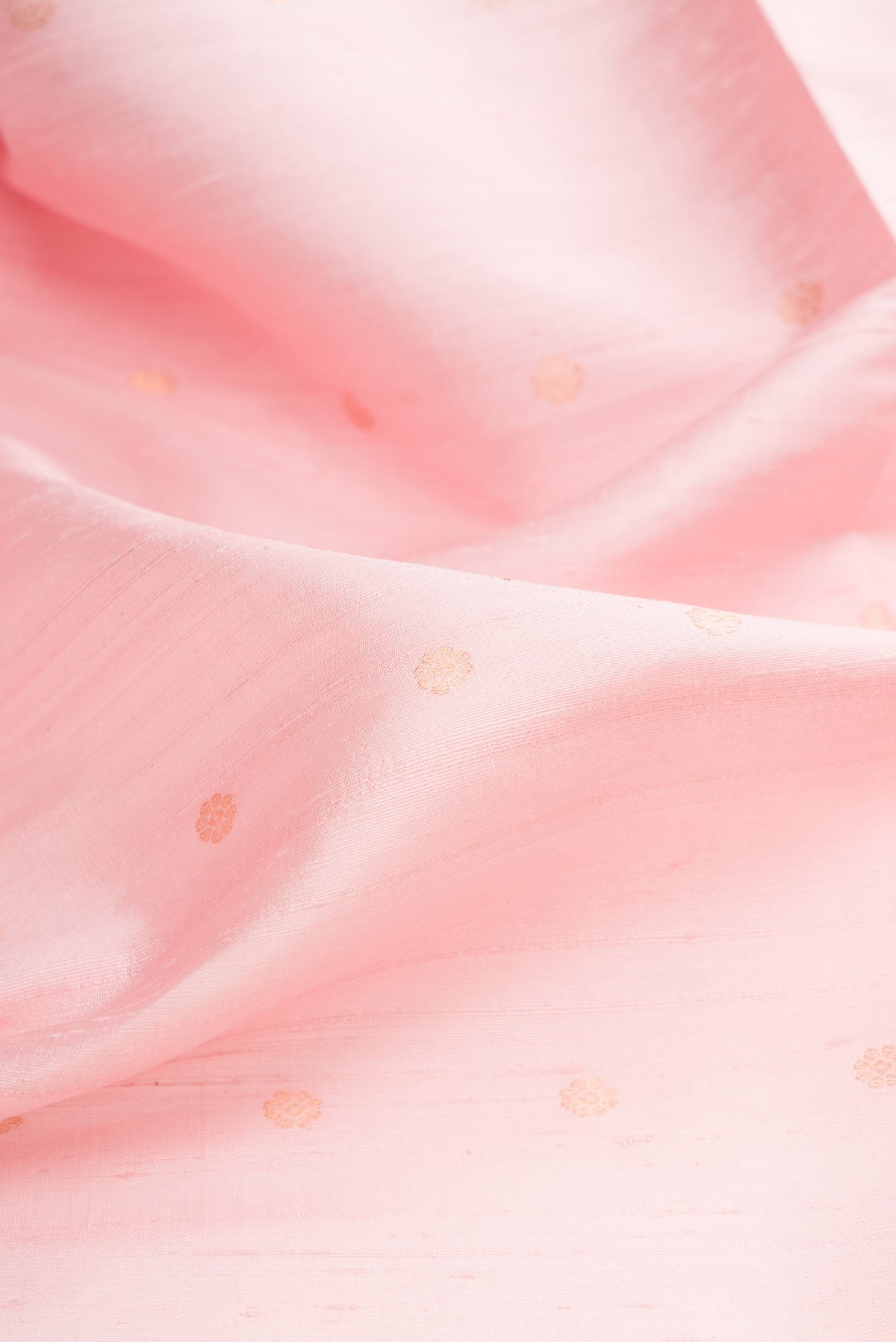 Close up of Rose pink Raw Saree with Zari Butta on the body and Zari Border.  displaying folds