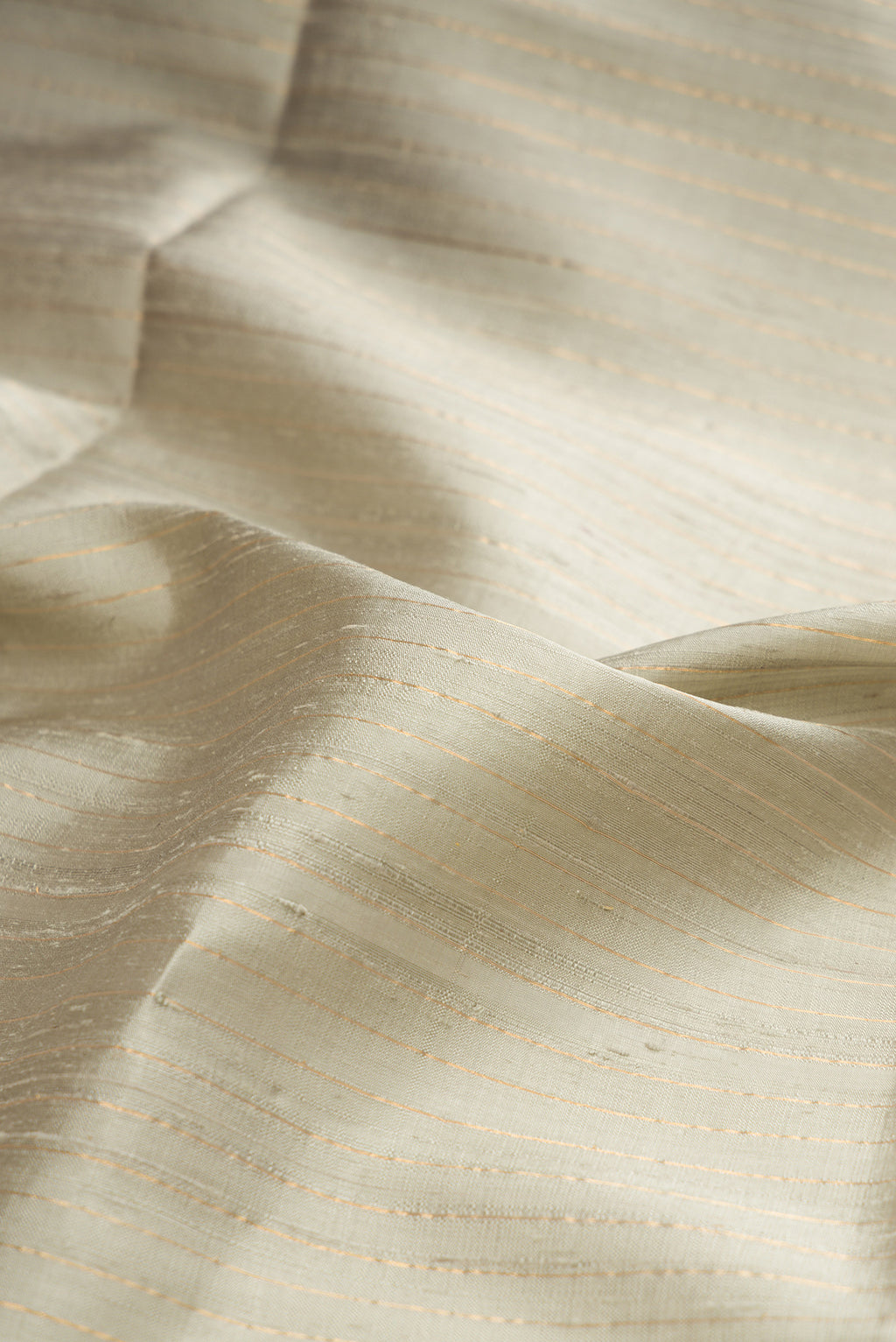 Close up of Pure Silk Grey Raw Saree with Stripes on the body and Fancy Border.  displaying folds