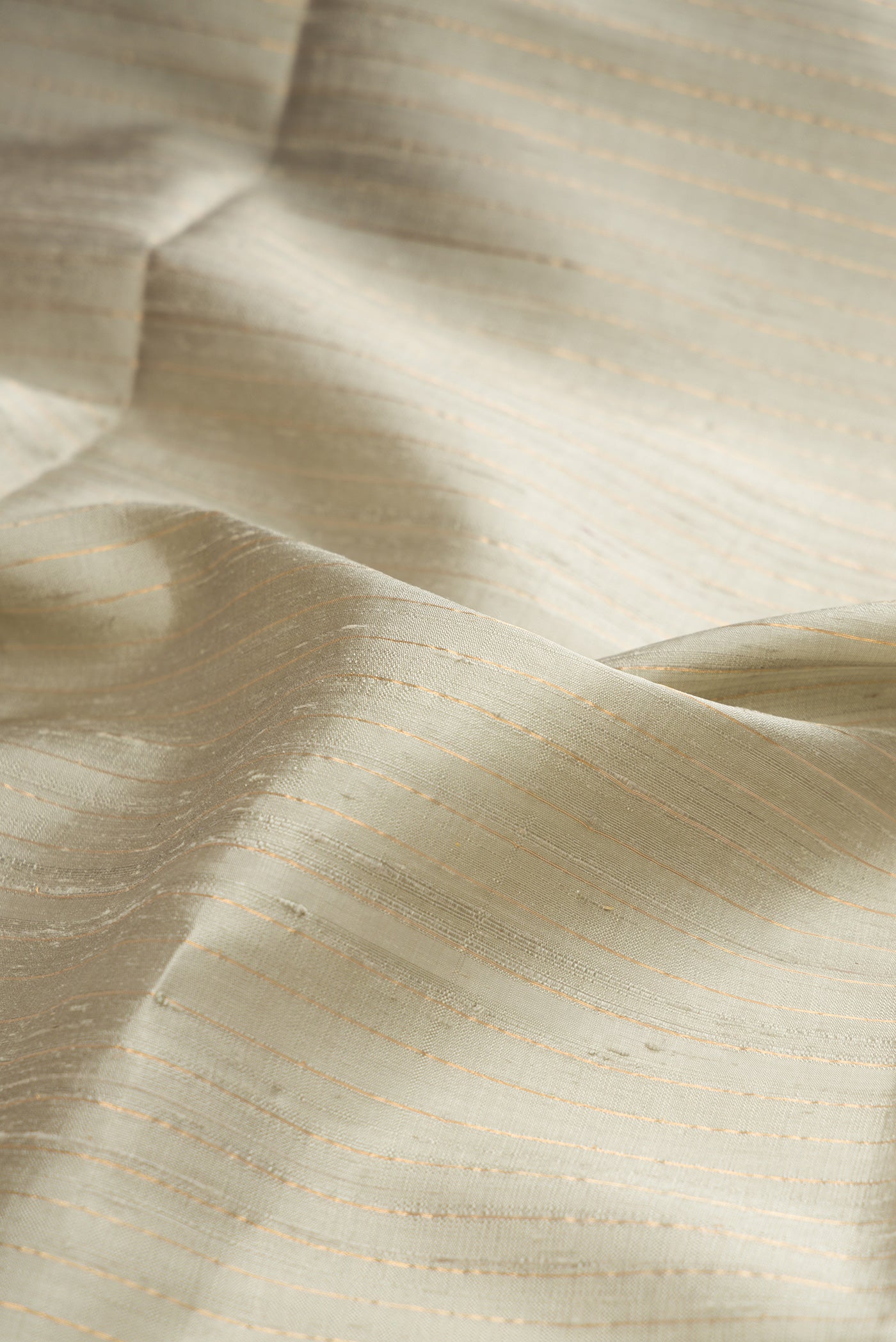 Close up of Pure Silk Grey Raw Saree with Stripes on the body and Fancy Border.  displaying folds
