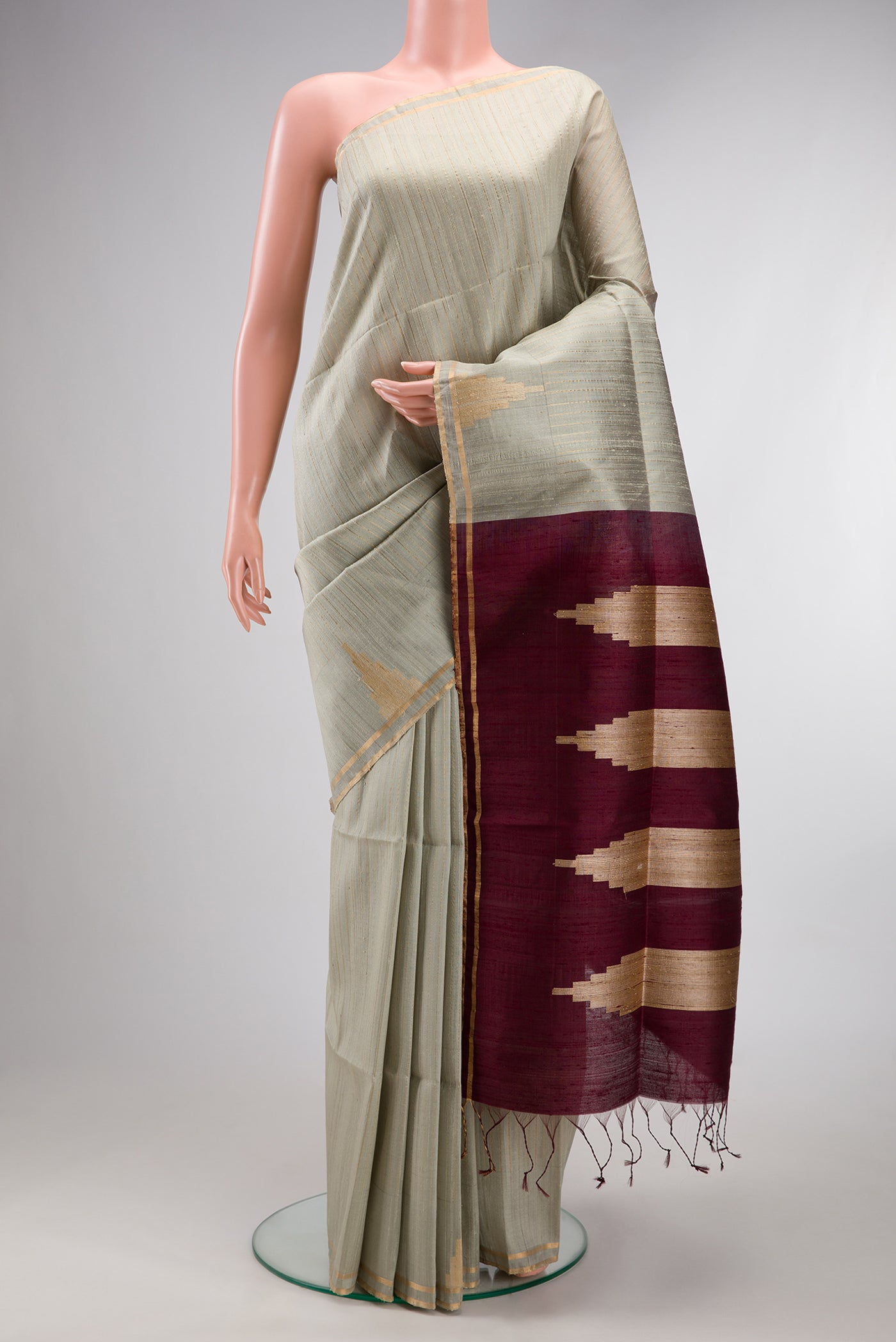 Pure Silk Grey Raw Saree with Stripes on the body and Fancy Border.  displayed on a mannequin