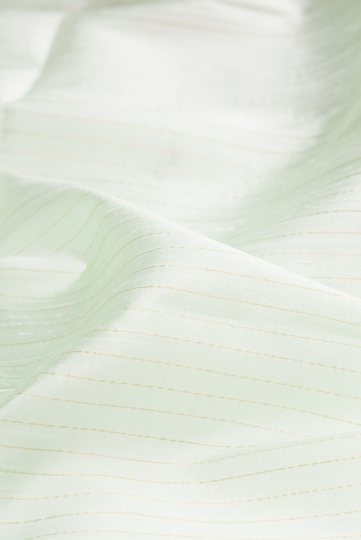 Close up of Pure Silk Mint Green Raw Saree with Stripes on the body and Fancy Border.  displaying folds