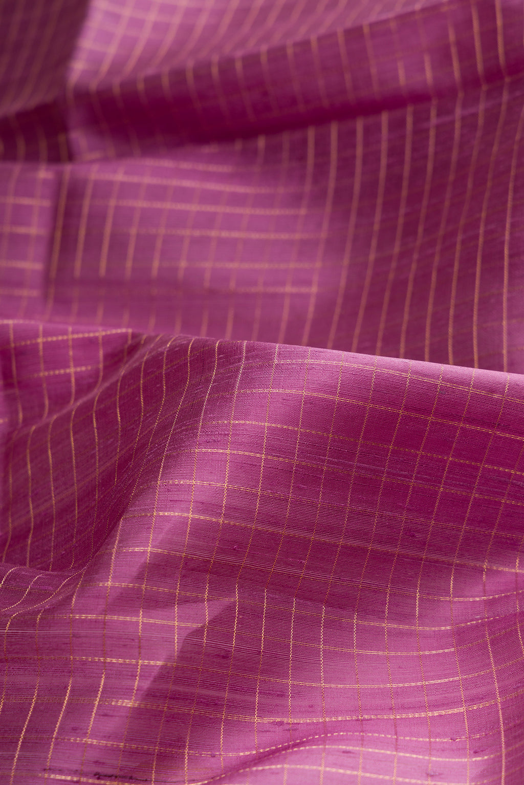 Close up of Pure Silk Purple Raw Saree with Checked design on the body and Fancy Border.  displaying folds