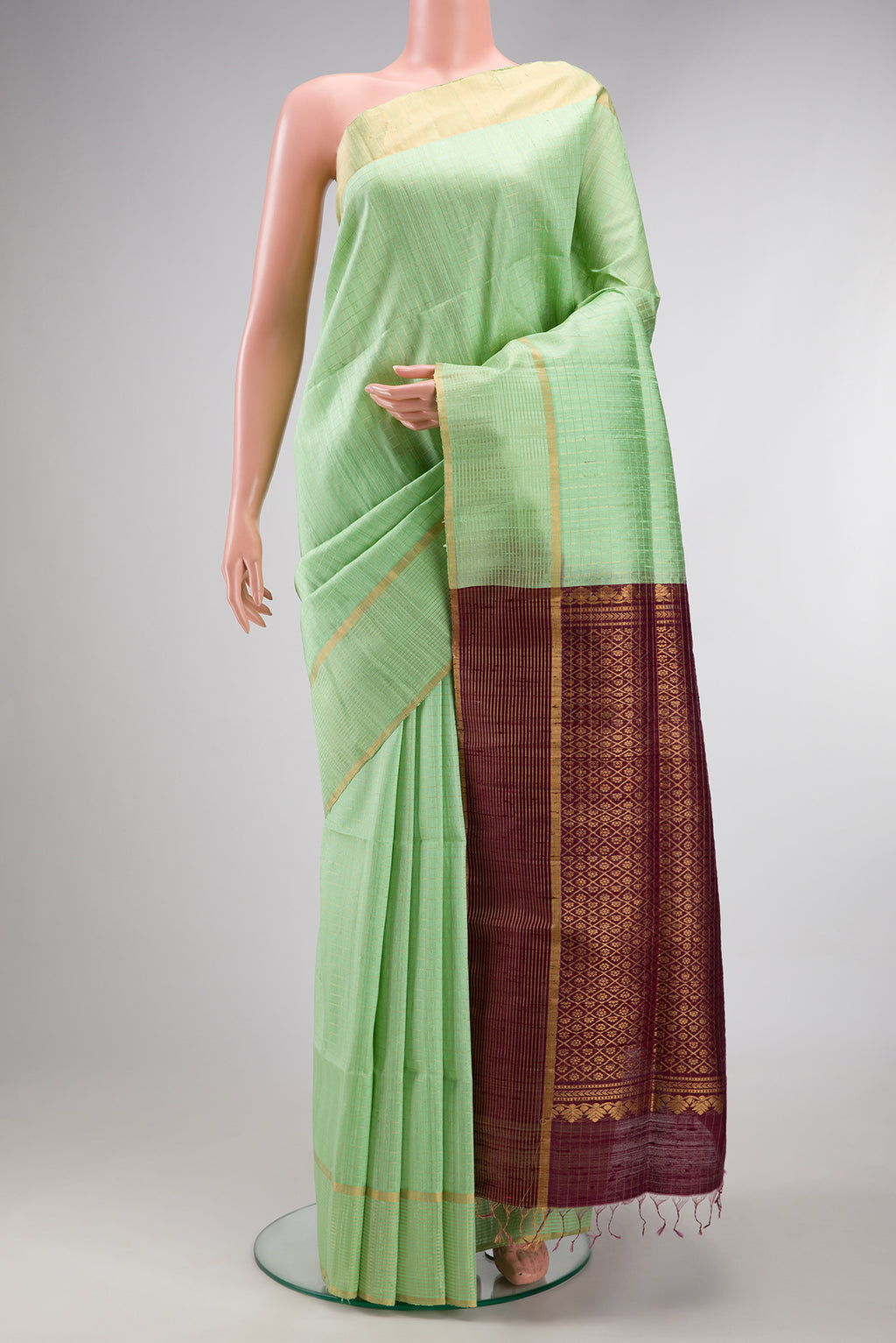 Pure Silk Pista Green Raw Saree with Checked design on the body and Fancy Border.  displayed on a mannequin