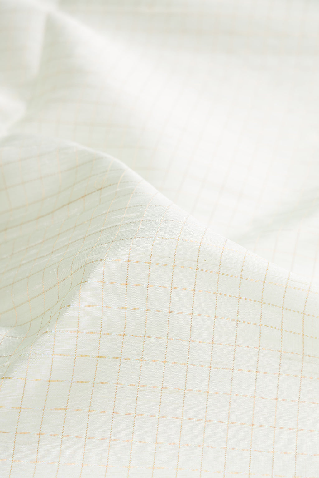 Close up of Pure Silk Off White Raw Saree with Checked design on the body and Zari Border.  displaying folds