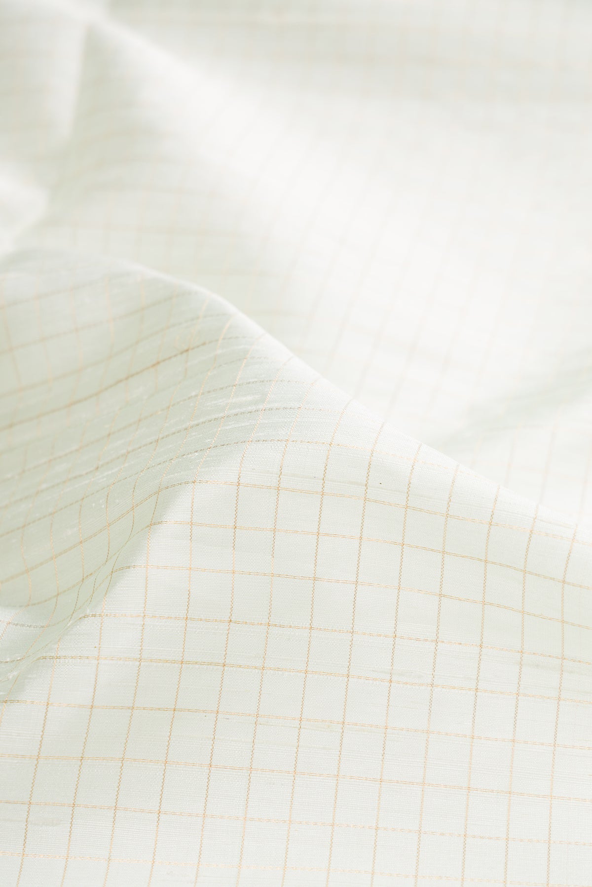 Close up of Pure Silk Off White Raw Saree with Checked design on the body and Zari Border.  displaying folds