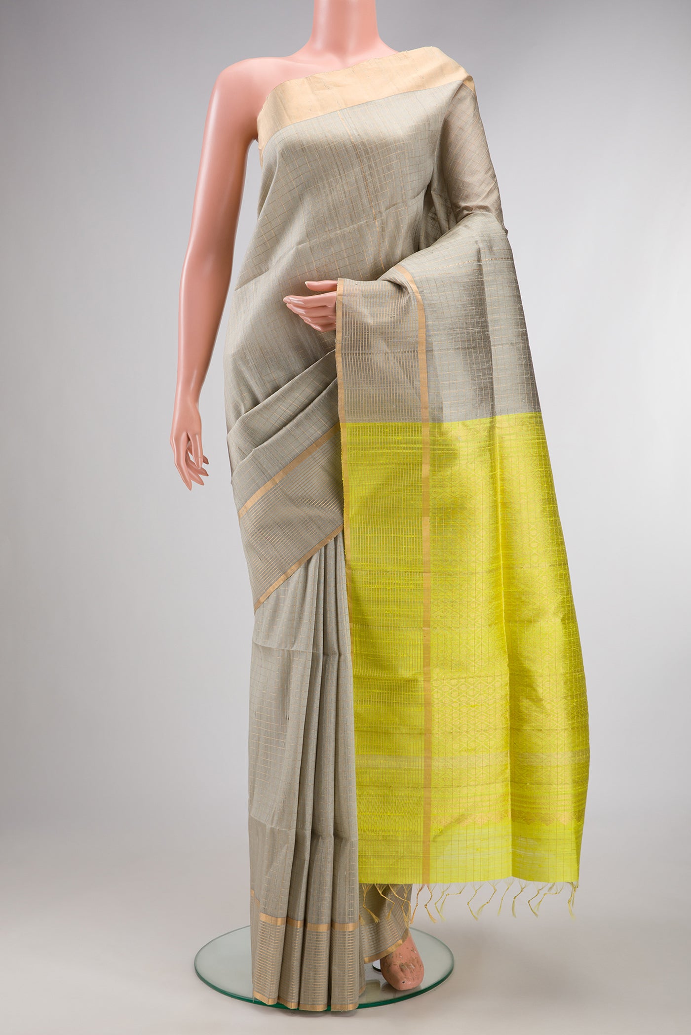 Pure Silk Grey Raw Saree with Checked design on the body and Fancy Border.  displayed on a mannequin