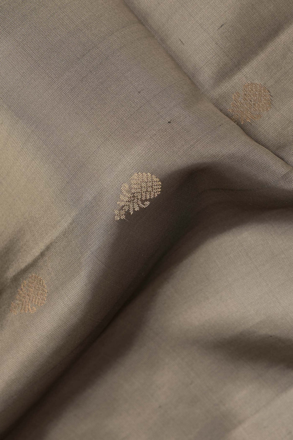 Close up of Pure Silk Grey Dual Tone Soft Saree with Zari Butta on the body and Fancy Border.  displaying folds