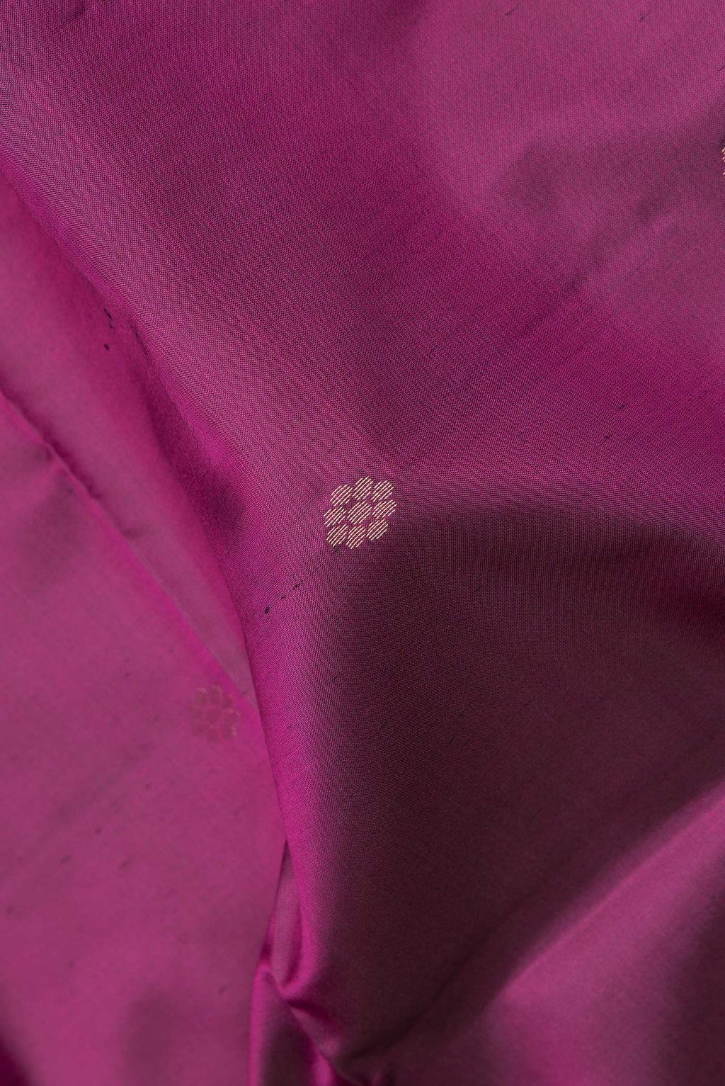 Close up of Pure Silk Magenta Dual Tone Soft Saree with Zari Butta on the body and Fancy Border.  displaying folds