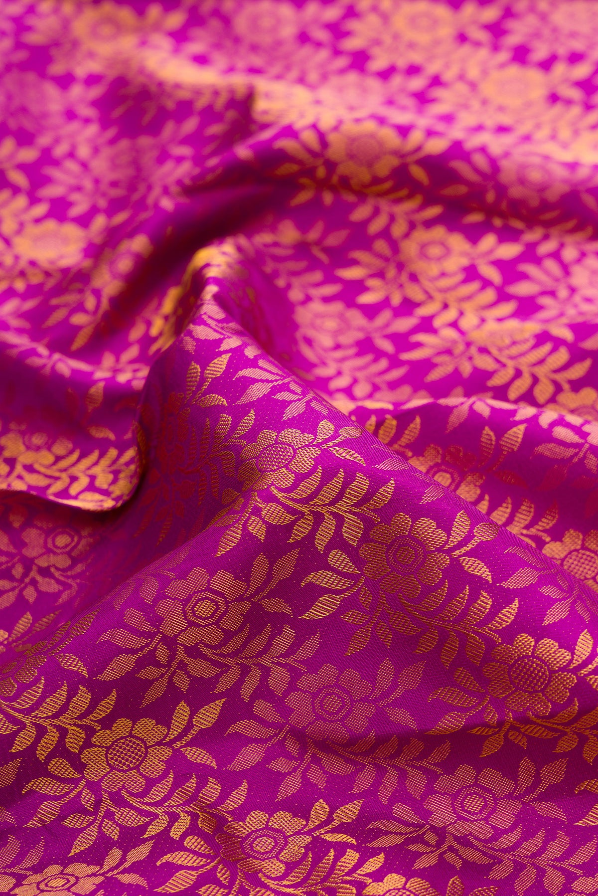 Close up of Pure Silk Magenta Kanchipuram Saree with Zari Brocade on the body and Zari Border.  displaying folds