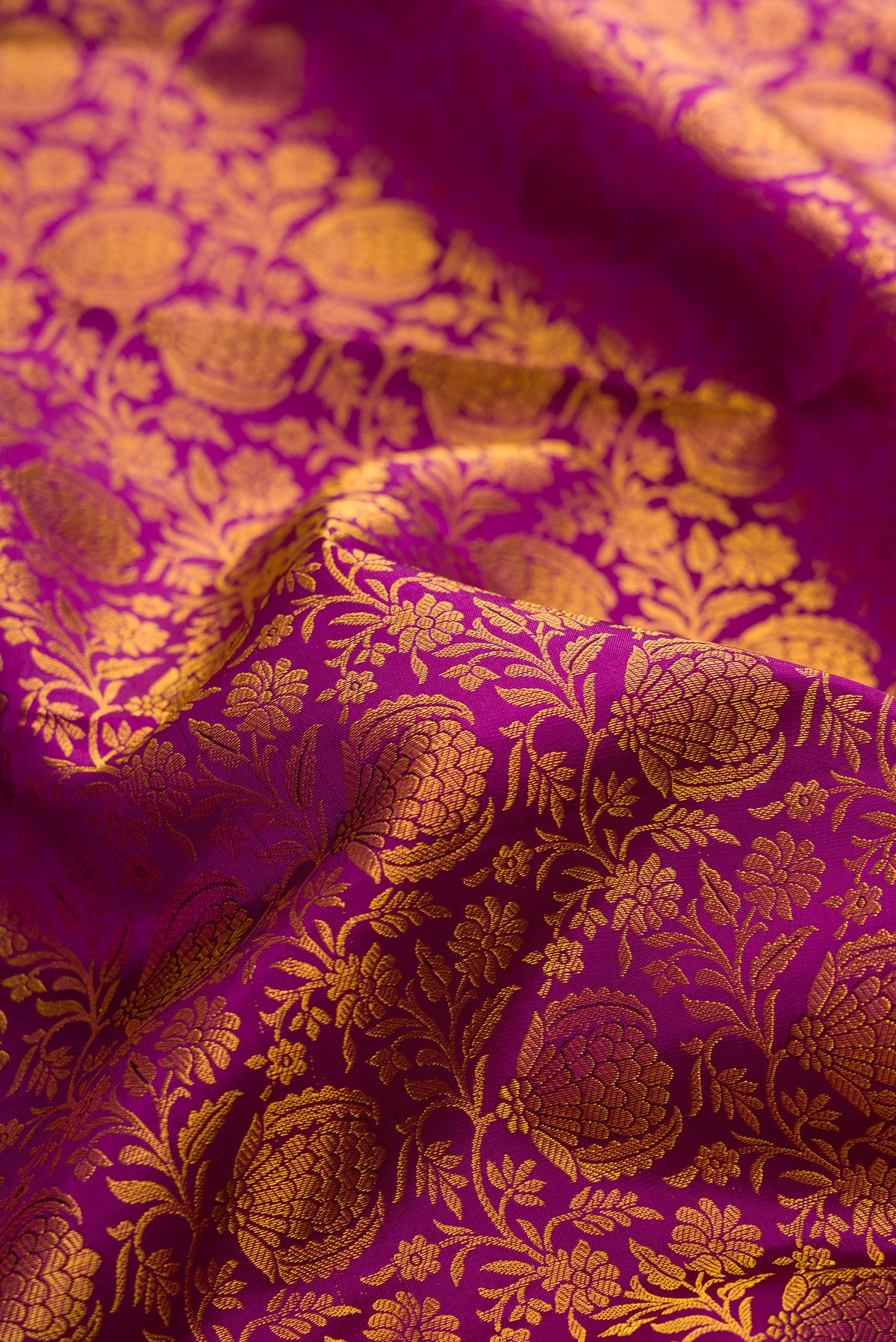 Close up of Pure Silk Magenta Kanchipuram Saree with Zari Brocade on the body and Zari Border.  displaying folds