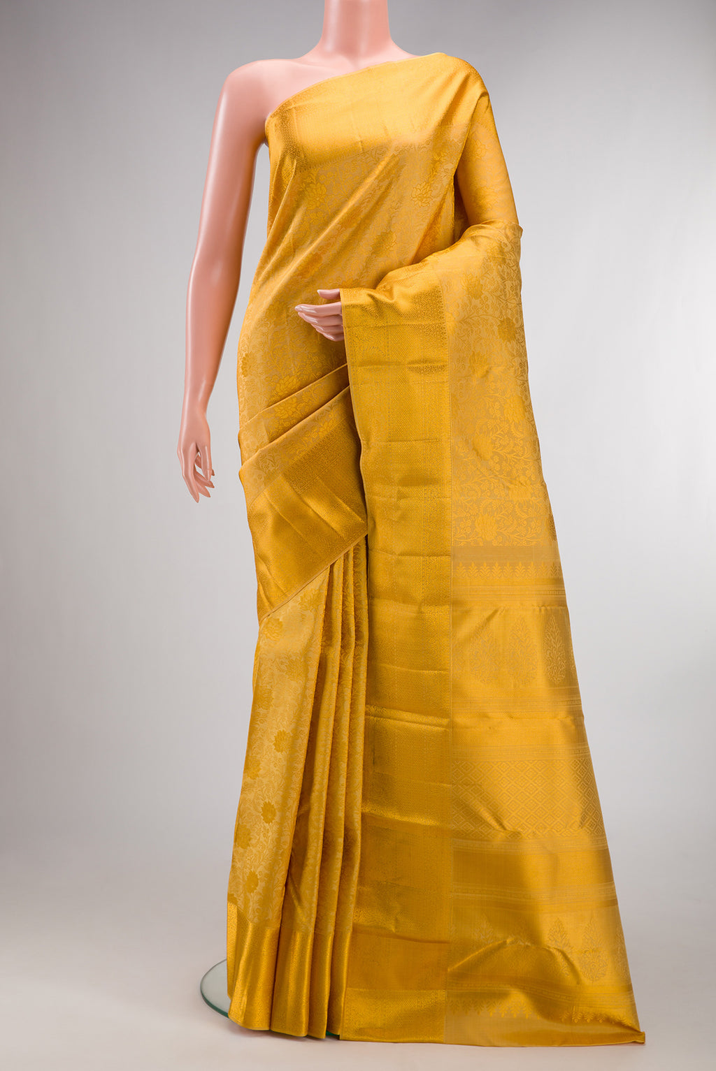 Pure Silk Gold Kanchipuram Saree with Zari Brocade on the body and Zari Border.  displayed on a mannequin