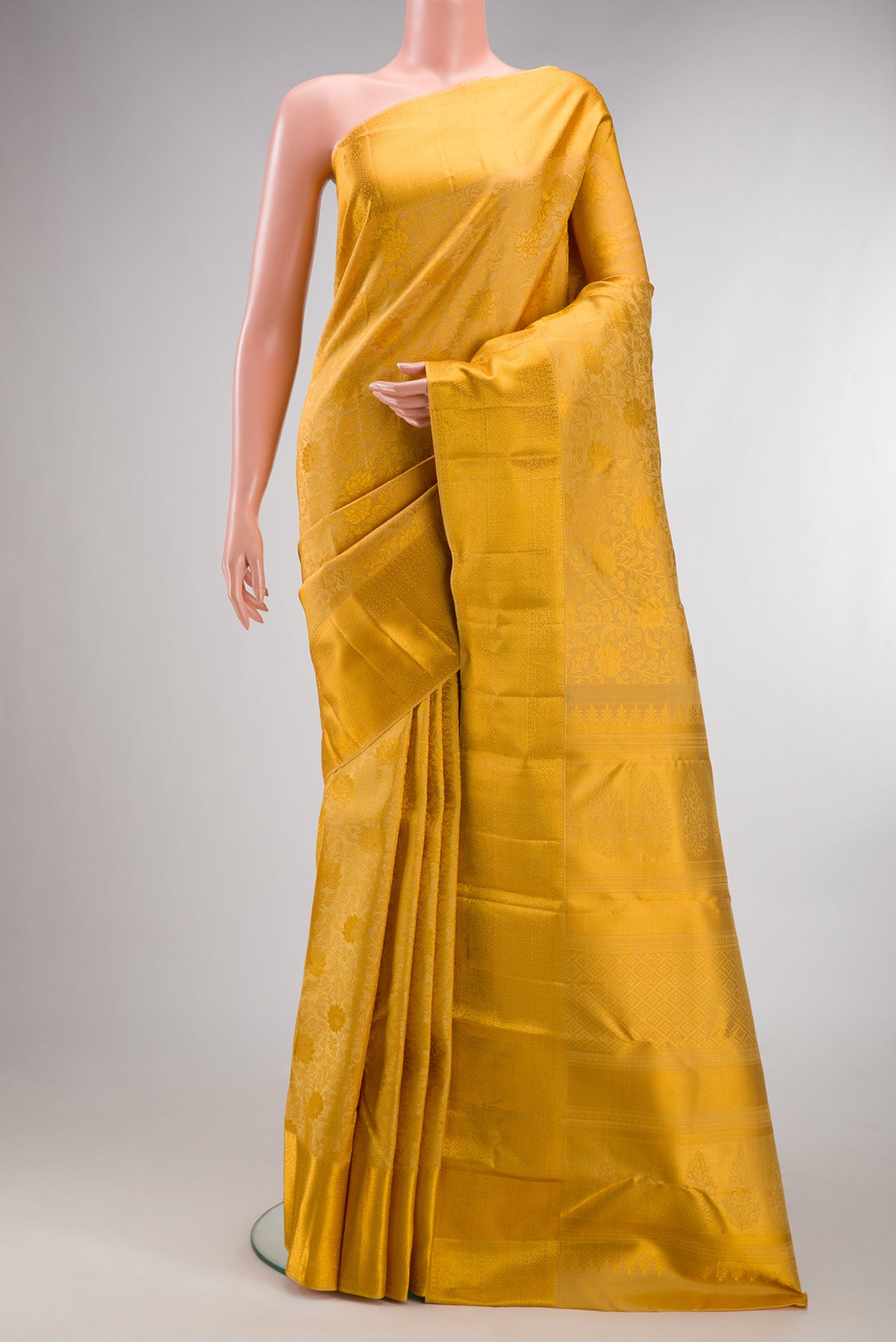 Pure Silk Gold Kanchipuram Saree with Zari Brocade on the body and Zari Border.  displayed on a mannequin
