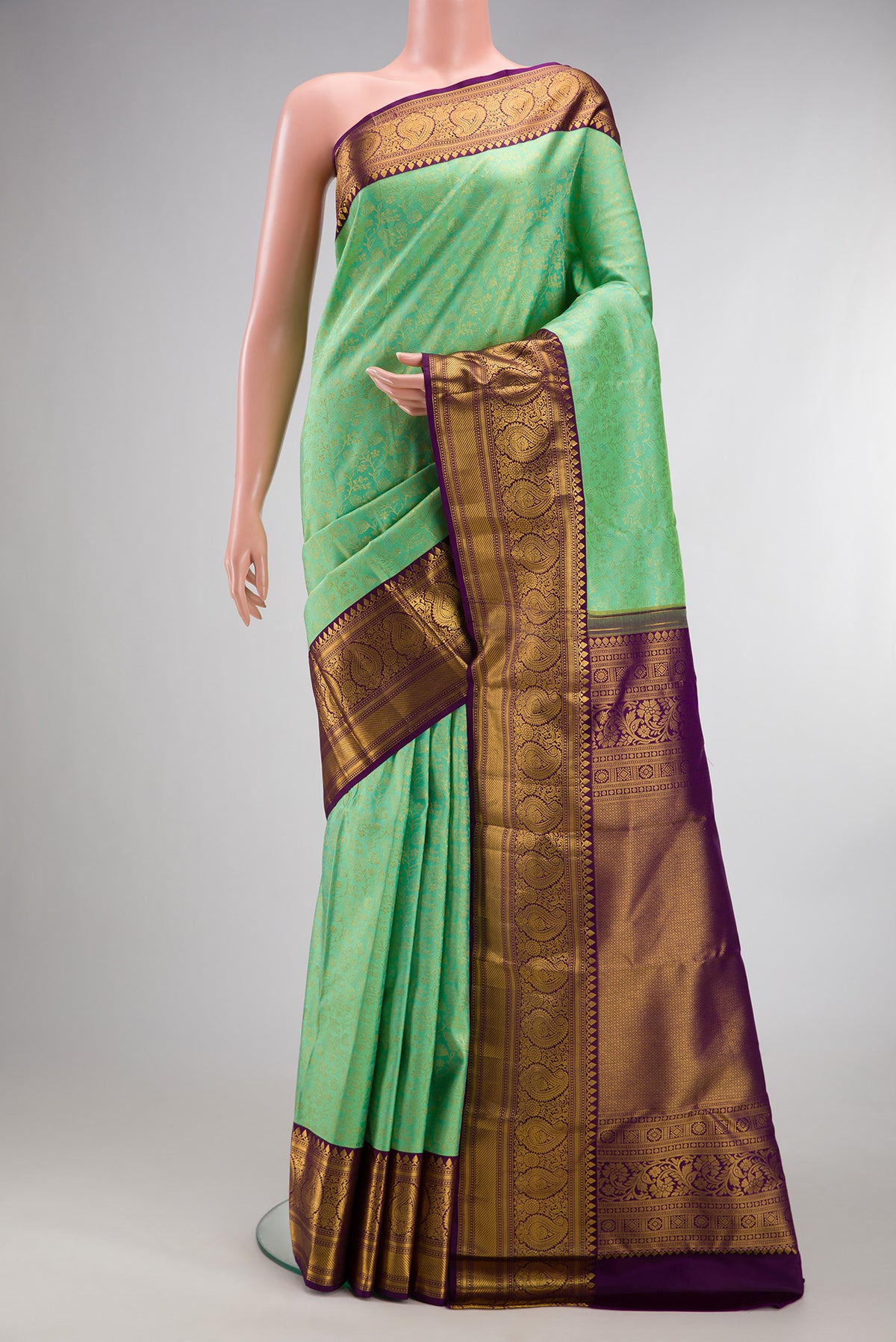 Pure Silk Pista Green Kanjivaram Saree with Zari Brocade on the body and Zari Border.  displayed on a mannequin