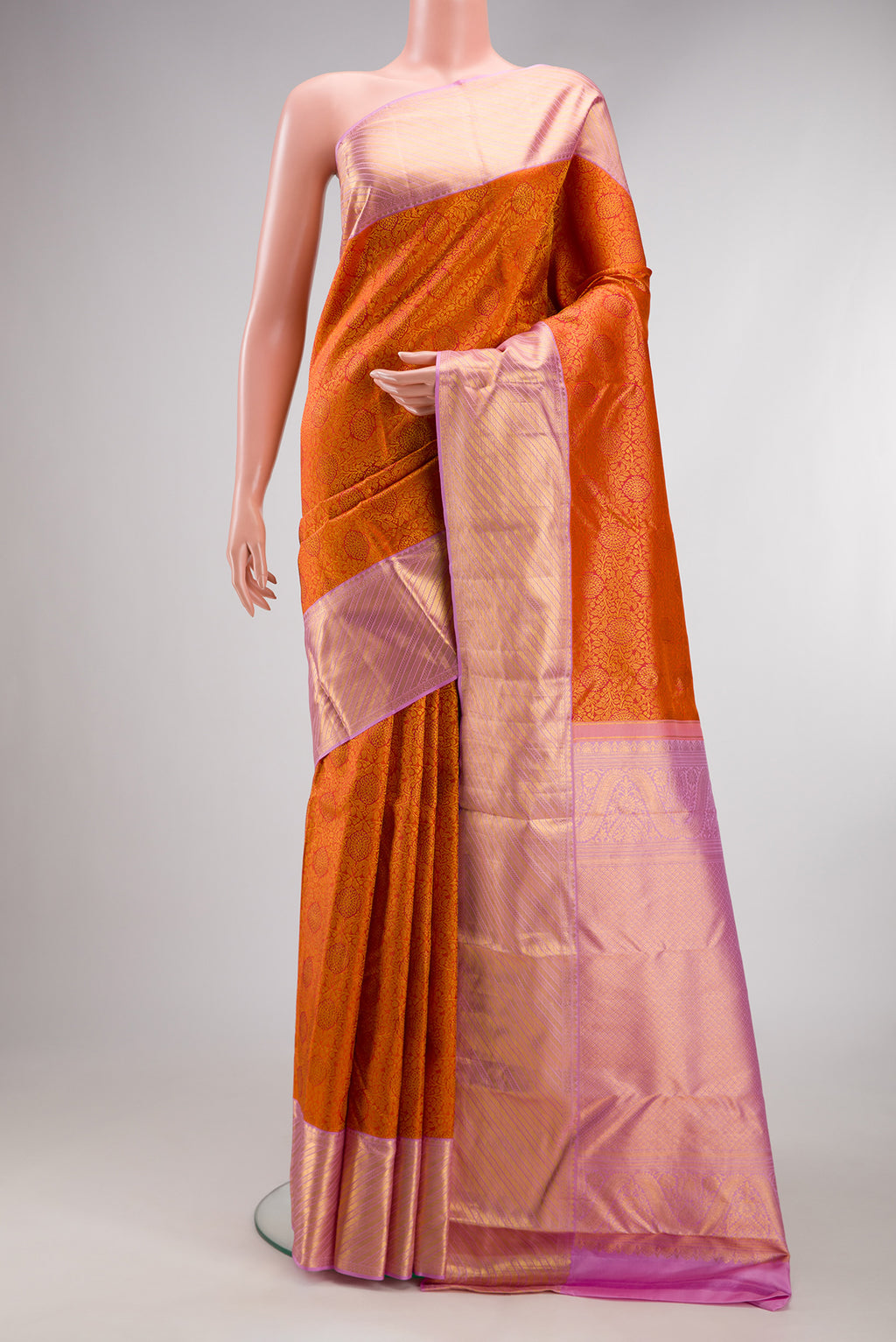 Orange Kanjivaram Silk Saree with Zari Brocade on the body and Fancy Border.  displayed on a mannequin